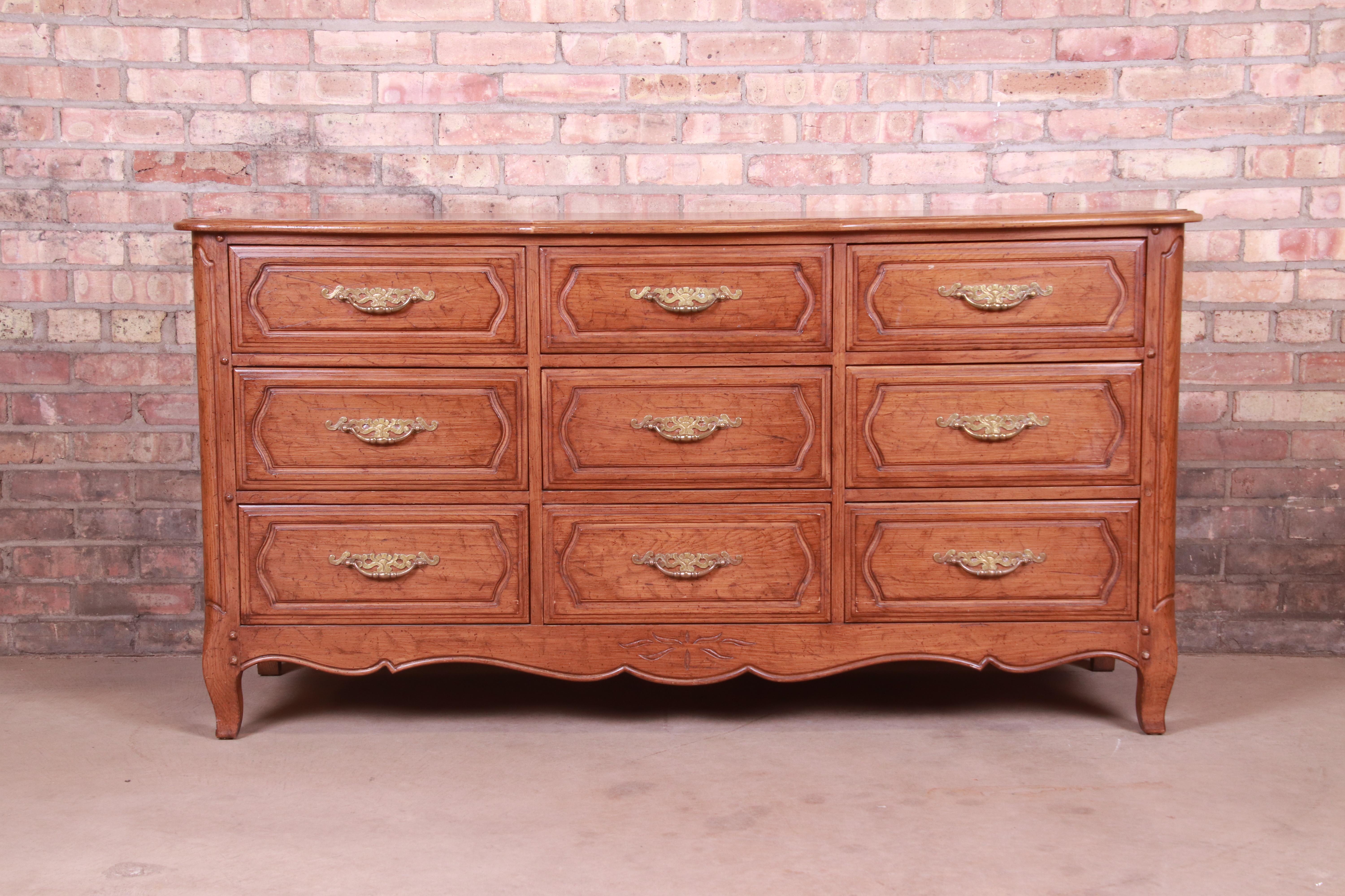 An exceptional French Provincial Louis XV style long dresser or credenza

By Davis Cabinet Co.

USA, Circa 1960s

Carved oak, with original brass hardware.

Measures: 60