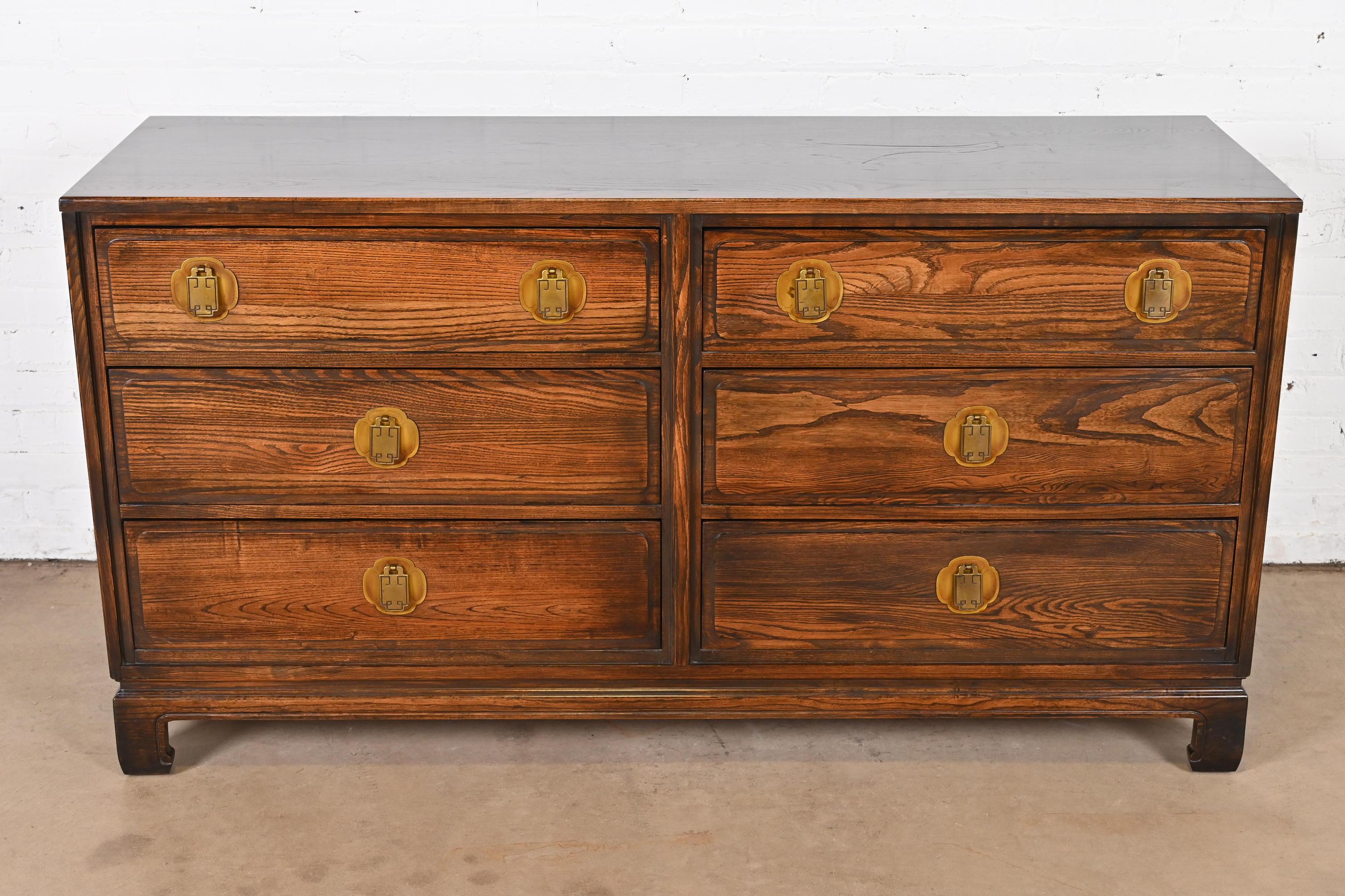 A gorgeous Mid-Century Modern Hollywood Regency Chinoiserie six-drawer dresser or chest of drawers

By Davis Cabinet Co.

USA, Circa 1960s

Carved oak, with original Asian inspired brass hardware.

Measures: 59.5