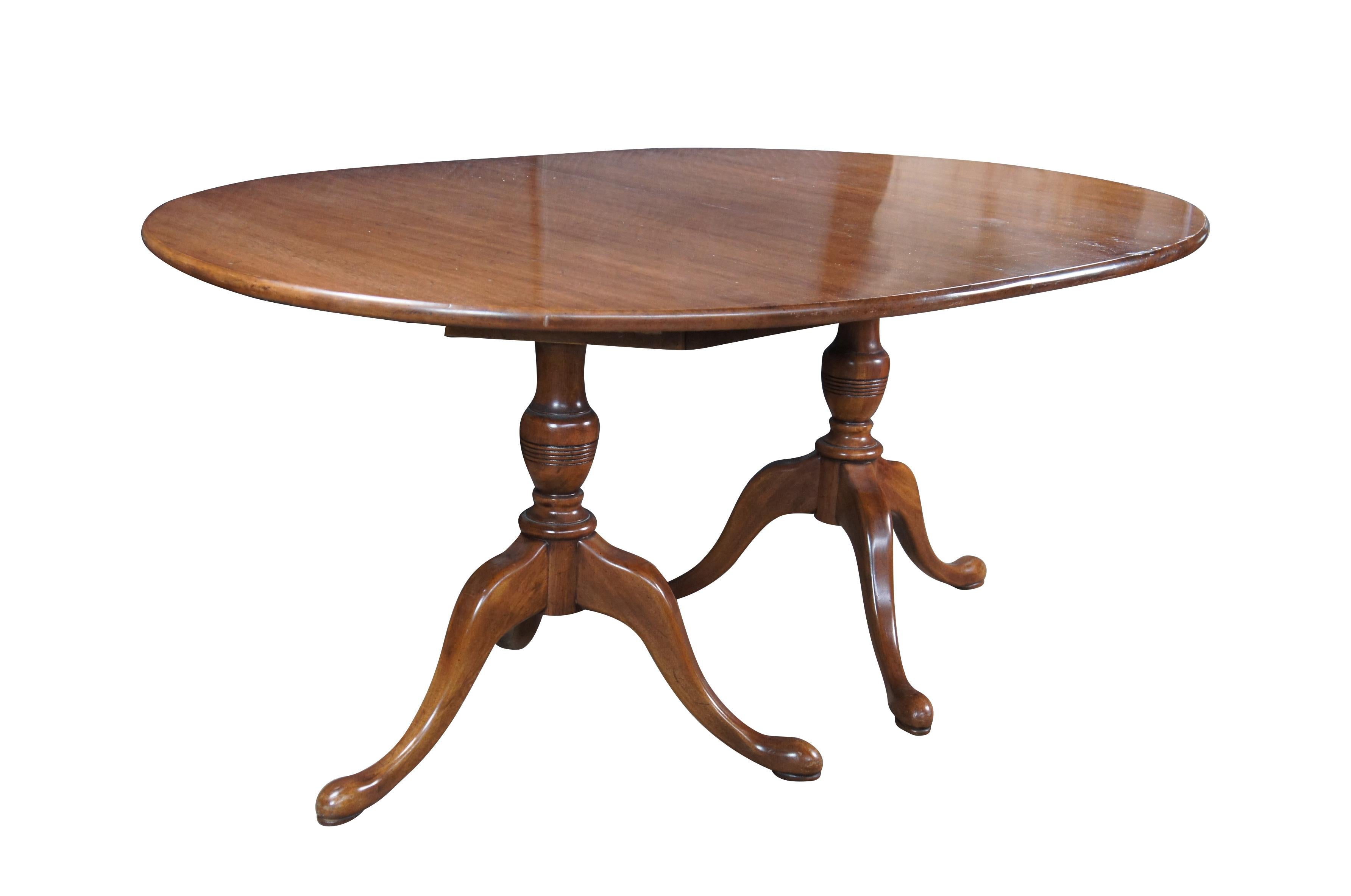 Tavolo da pranzo ovale vintage Davis Cabinet Company Cumberland Valley #1257, anni '60 circa.  Presenta una struttura in noce invecchiato su una base a doppio piedistallo con sostegni a balaustro torniti ad anello su gambe a piombo con piedini a