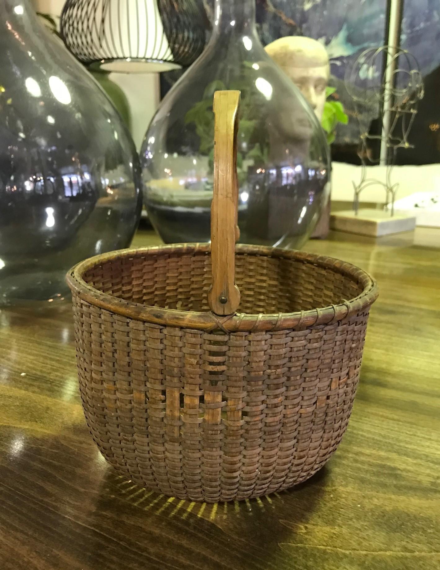 A wonderful and quite rare and hard to find nantucket lightship basket by Davis Hall, (1828-1906). Hall's baskets are prized by collectors of lightship baskets worldwide. This basket is made with his traditional swing handle and rounded lollipop