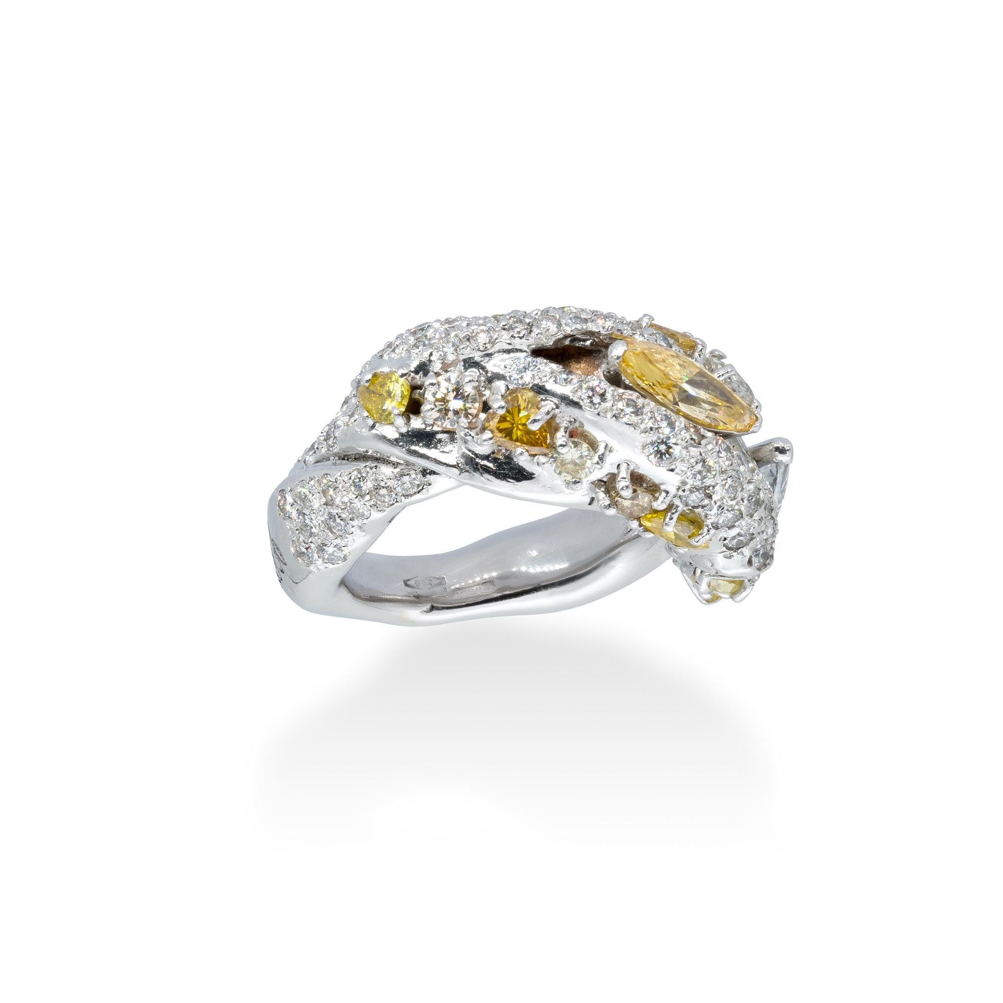 White gold Ring with two central Diamonds marquise cut, one of them Fancy Yellow and the other White, G Color, VVS1, on a pavé of 2.40 cts of white diamonds and two rows of fancy yellow diamonds.
White and fancy yellow diamonds are set together in