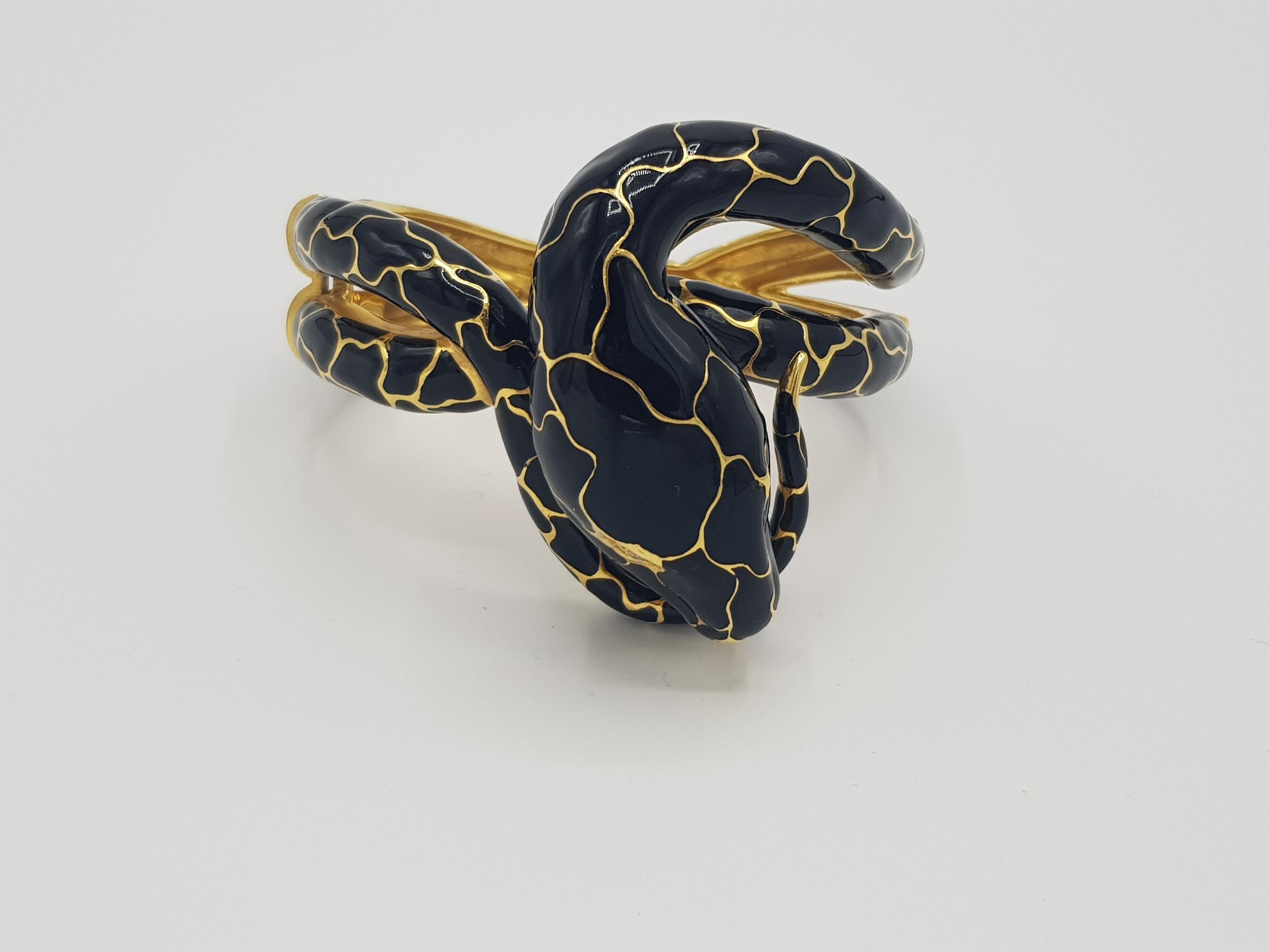 d'Avossa Snake Bracelet , in 18Kt yellow gold and black enamel, is the symbol of grace, seduction and mystery.
Two white Diamonds sparkle in the eyes.

Unique Piece