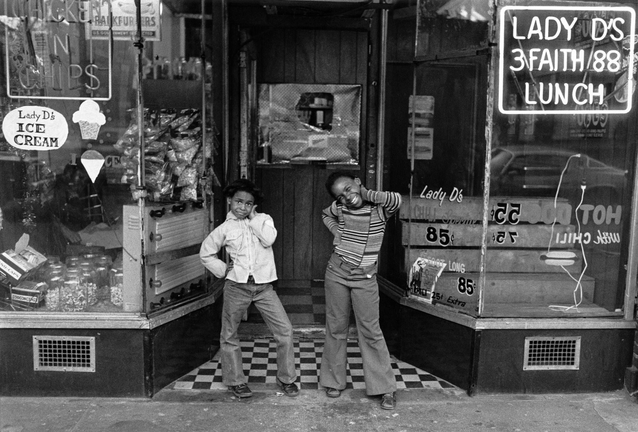Dawoud Bey Two Girls at Lady D’s, Harlem, 1976:
“I spent five years in the mid-to-late 1970s making photographs in Harlem, New York. It was the first project I undertook at the beginning of my career. I was led back there by my family’s history in