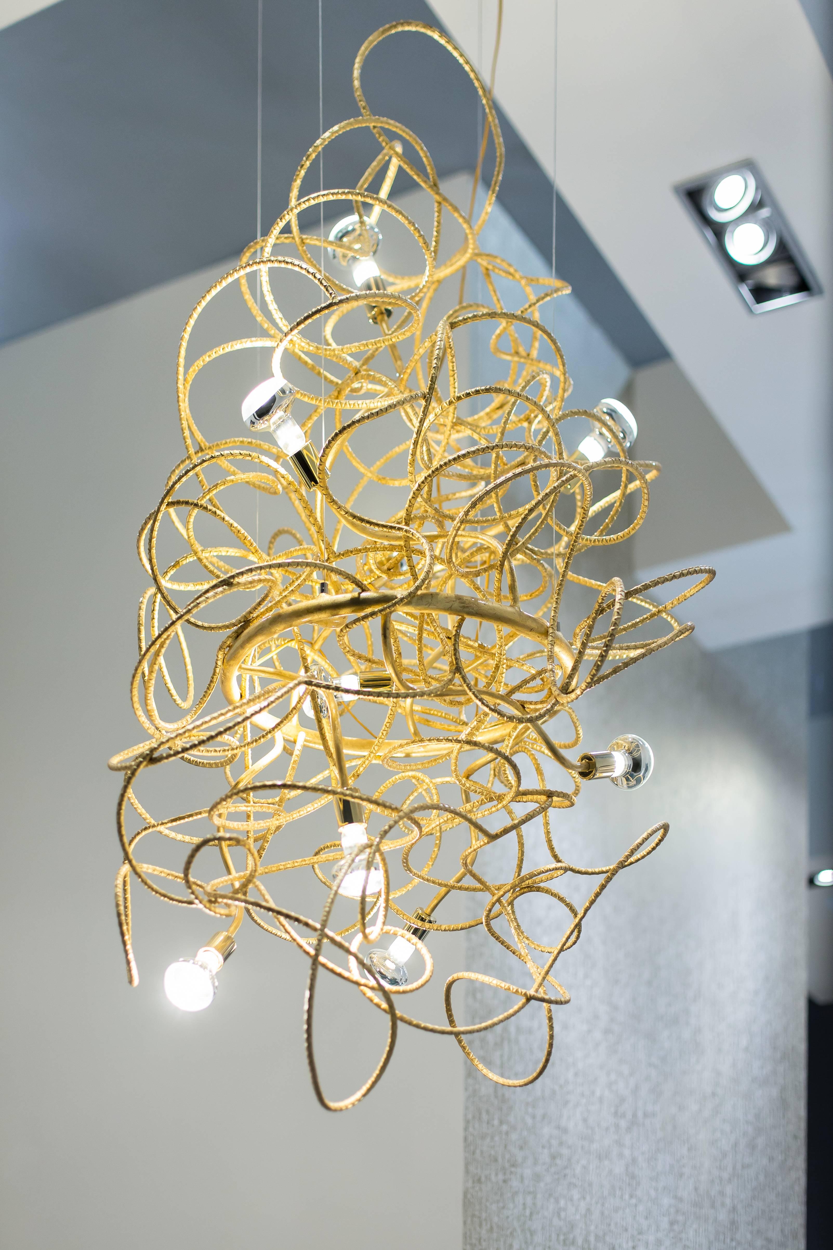 The Dax chandelier is a sculptural fete featuring gold leafed rebar hand twisted to create a unique one of a kind fixture. Polished brass and Carrara marble finish this piece off. 

Light bulbs: Nine, clear globe g25 standard base, 60 watt max