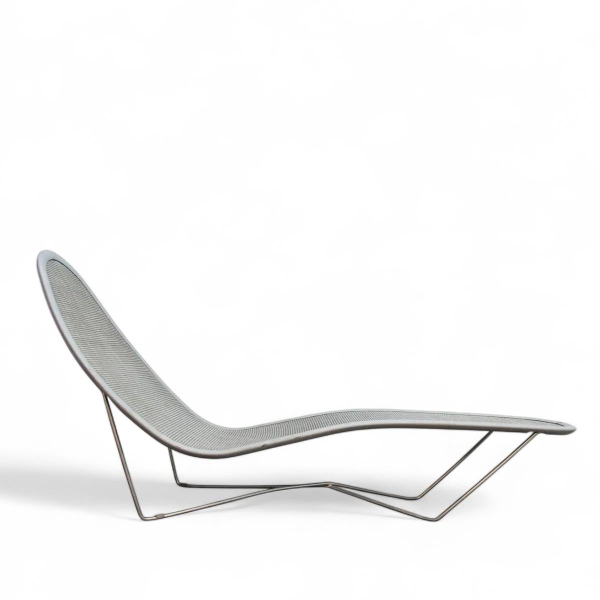 Le *Day Bed* (2000) de Ross Lovegrove illustre sa fusion de formes organiques et de design futuriste. Créée pour Loom, la chaise longue présente un cadre en acier épuré supportant une structure en aluminium laqué gris argenté, recouverte de sangles