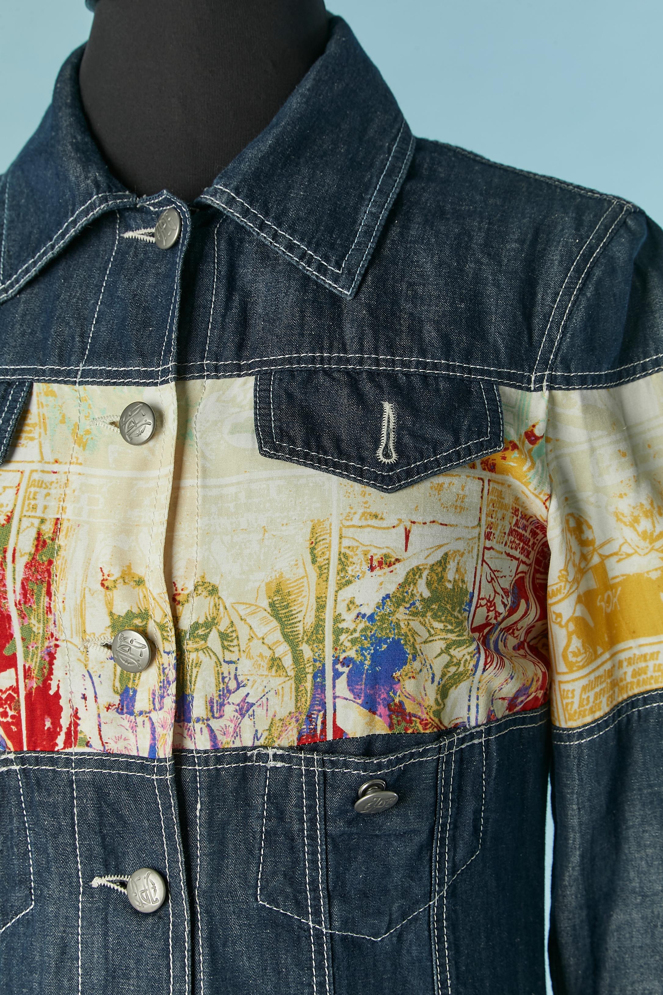 Abito bi-materiale composto da denim e tessuto stampato a fiori. Non c'è l'etichetta della composizione del tessuto, ma il denim è probabilmente cotone e il tessuto stampato è probabilmente rayon. Chiusura con bottoni con marchio sul centro davanti