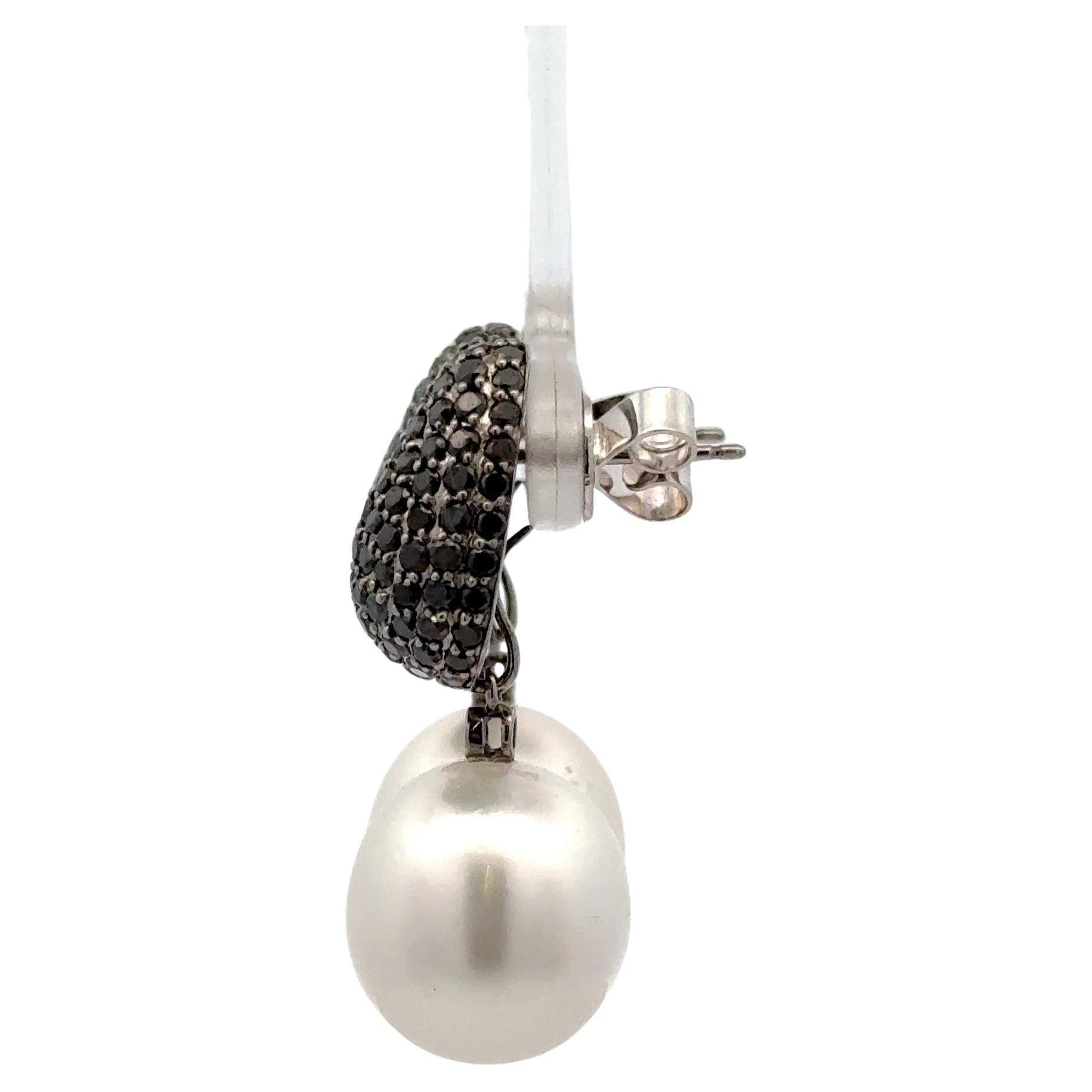 18K White gold drop earrings featuring 188 black diamonds weighing 2.80 carats and two South Sea Pearls measuring 13-14 mm. 

Pearls can be removed and wear just the diamonds. 