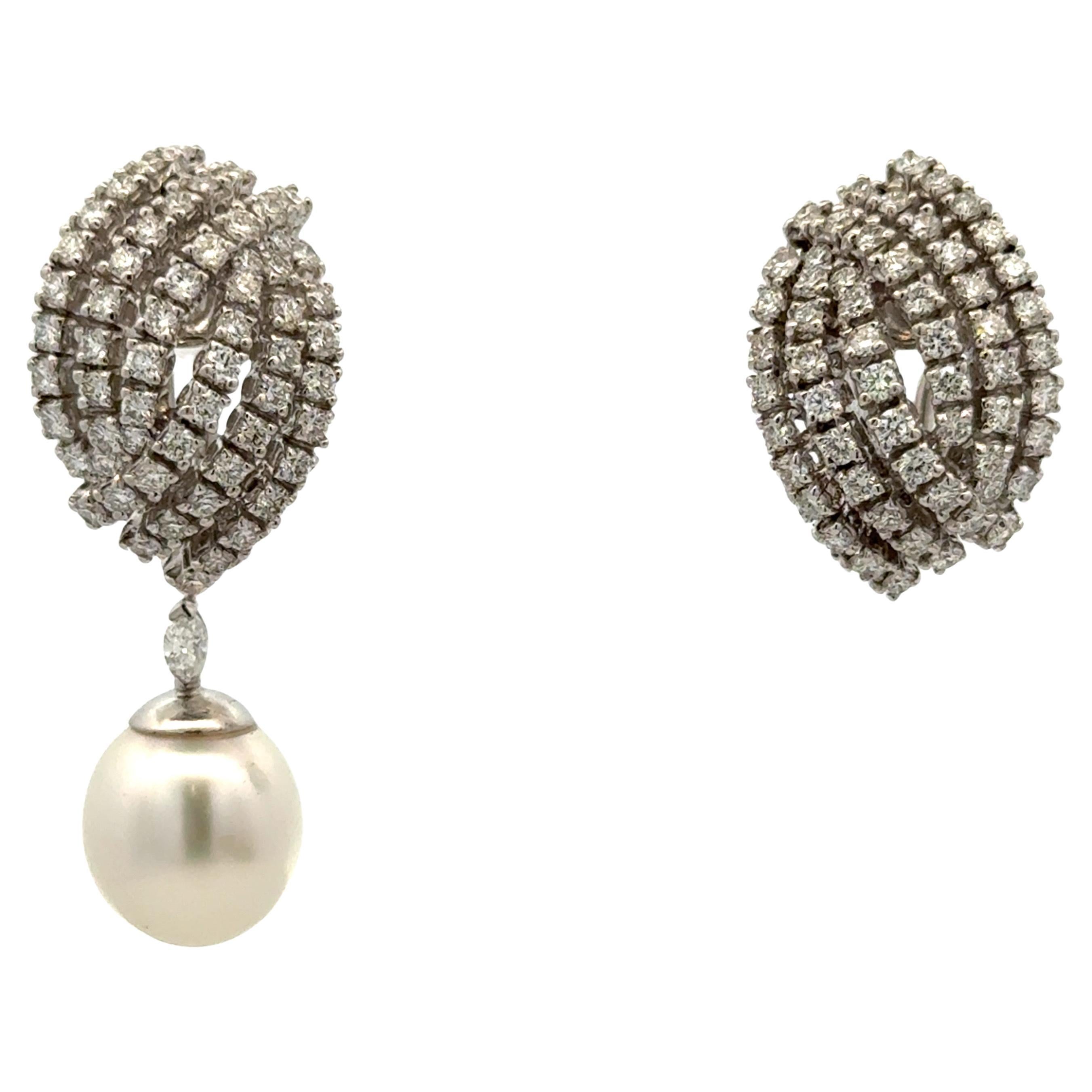 Orecchini a goccia da giorno e da notte con 118 Brillianti rotondi del peso di 2,61 carati e due Perle dei Mari del Sud di 11-12 mm, realizzati in oro bianco 18 carati. 
Brillianti rotondi - 2,40 Carati
Marquise - 0,16 Carati 

Le perle possono