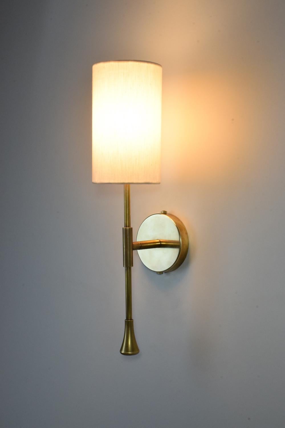 A timeless wall light built in a solid brass structure with a cylinder white fabric shade and optional modern or oriental hand-engravings on the wall plate and stem.

Light source
1 x 60 W Max G9
230 V - LED Integrated 
120 V - LED.

This piece is