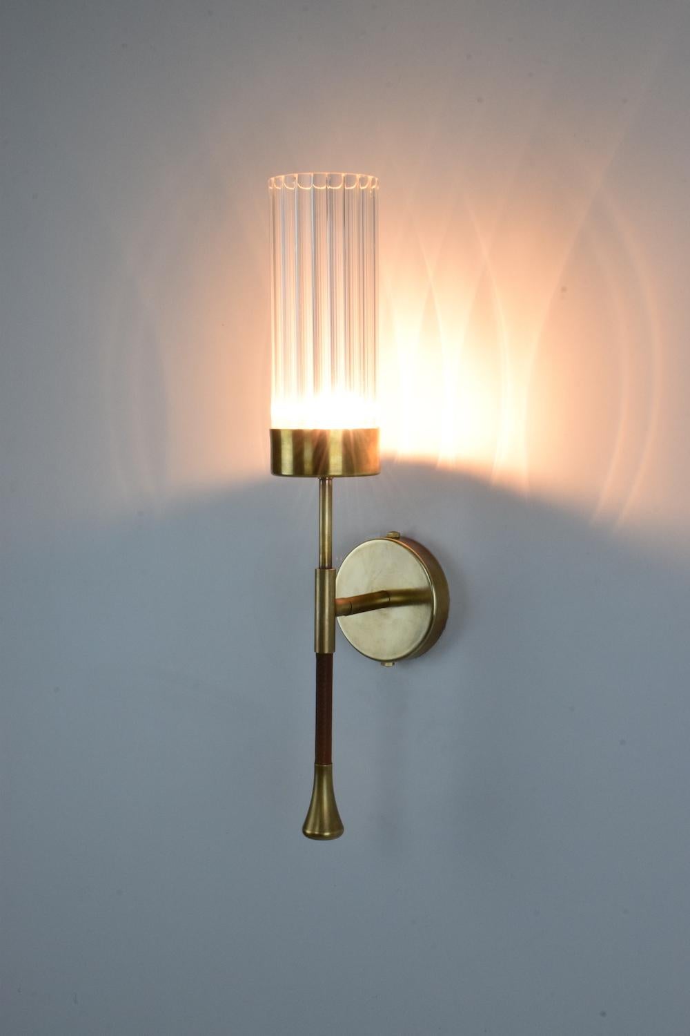 Designed in a timeless structure highlighted by a leather sheathed stem and cylindrical textured glass shade. Available as a single or double fixture and openwork brass details. 

Light source
1x60 W Max G9
230 V - LED Integrated
120 V -