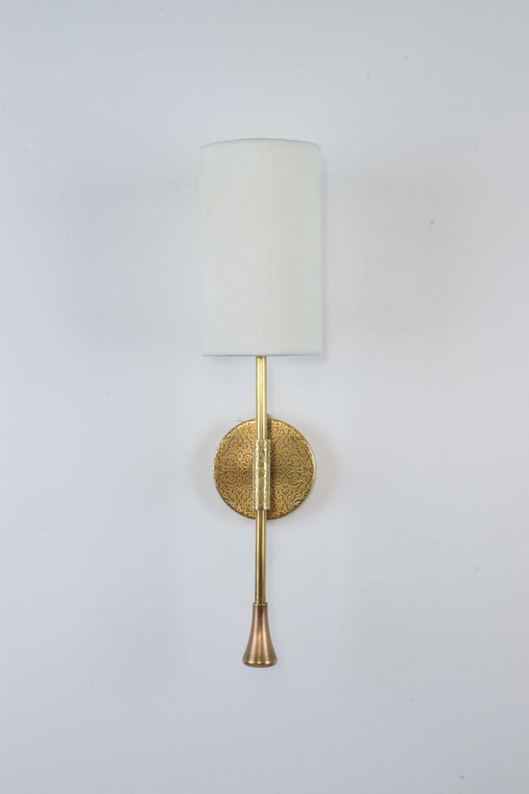 A timeless wall light built in a solid brass structure with a cylinder white fabric shade and oriental hand-engravings on the wall plate and stem.

Light source
1x60 W Max E14
230 V - LED Integrated 120 V - LED.

Flow 2 by JA Studio
The