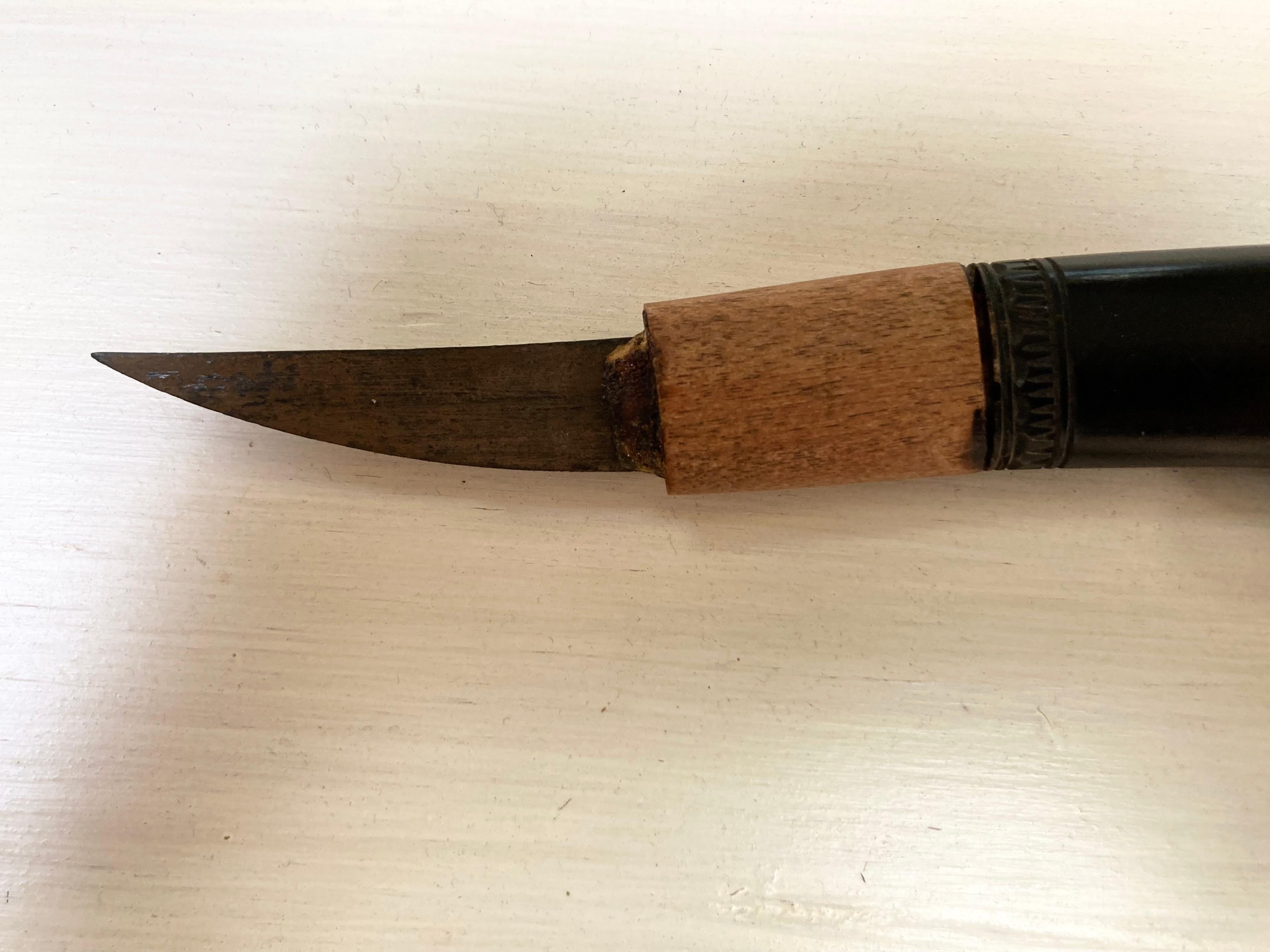 Couteau utilitaire pour homme en corne de buffle d'eau sculptée de forme traditionnelle. Utilisé pour des tâches dans les vastes zones forestières des tribus Dayak de Bornéo, ce couteau possède une lame en acier incurvée d'origine, logée dans une