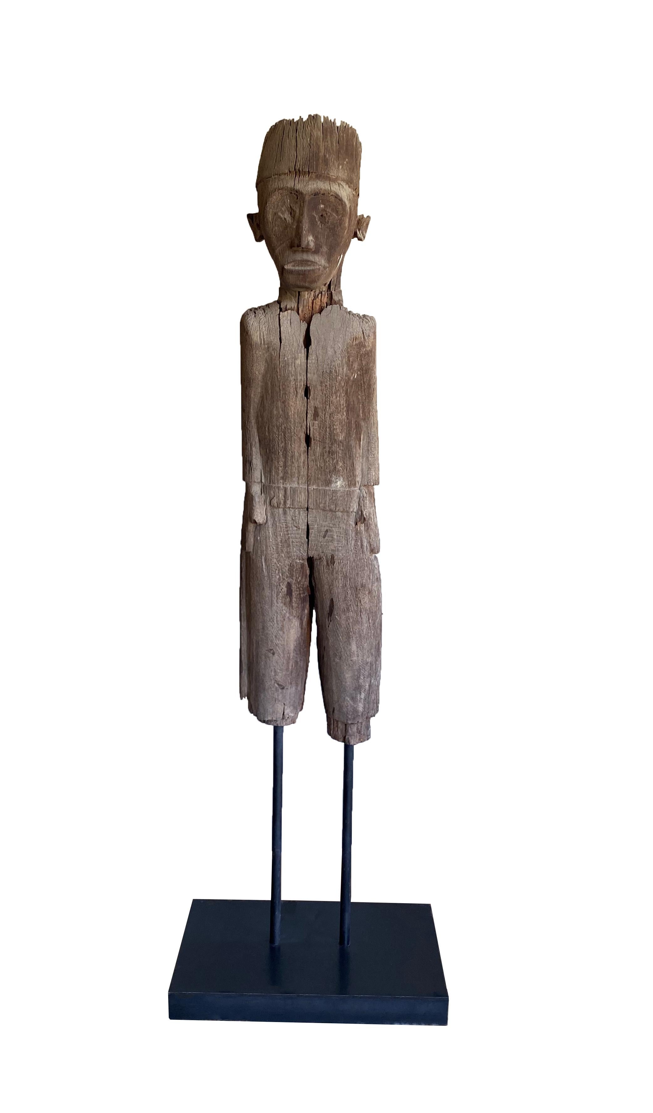 A Kalimantan carved standing sculpture of a man by the Dayak people from the interior rain forests of Borneo. Carved with a beautiful natural patina effect, this statue was originally used as a protective figure standing guard in front of tribe