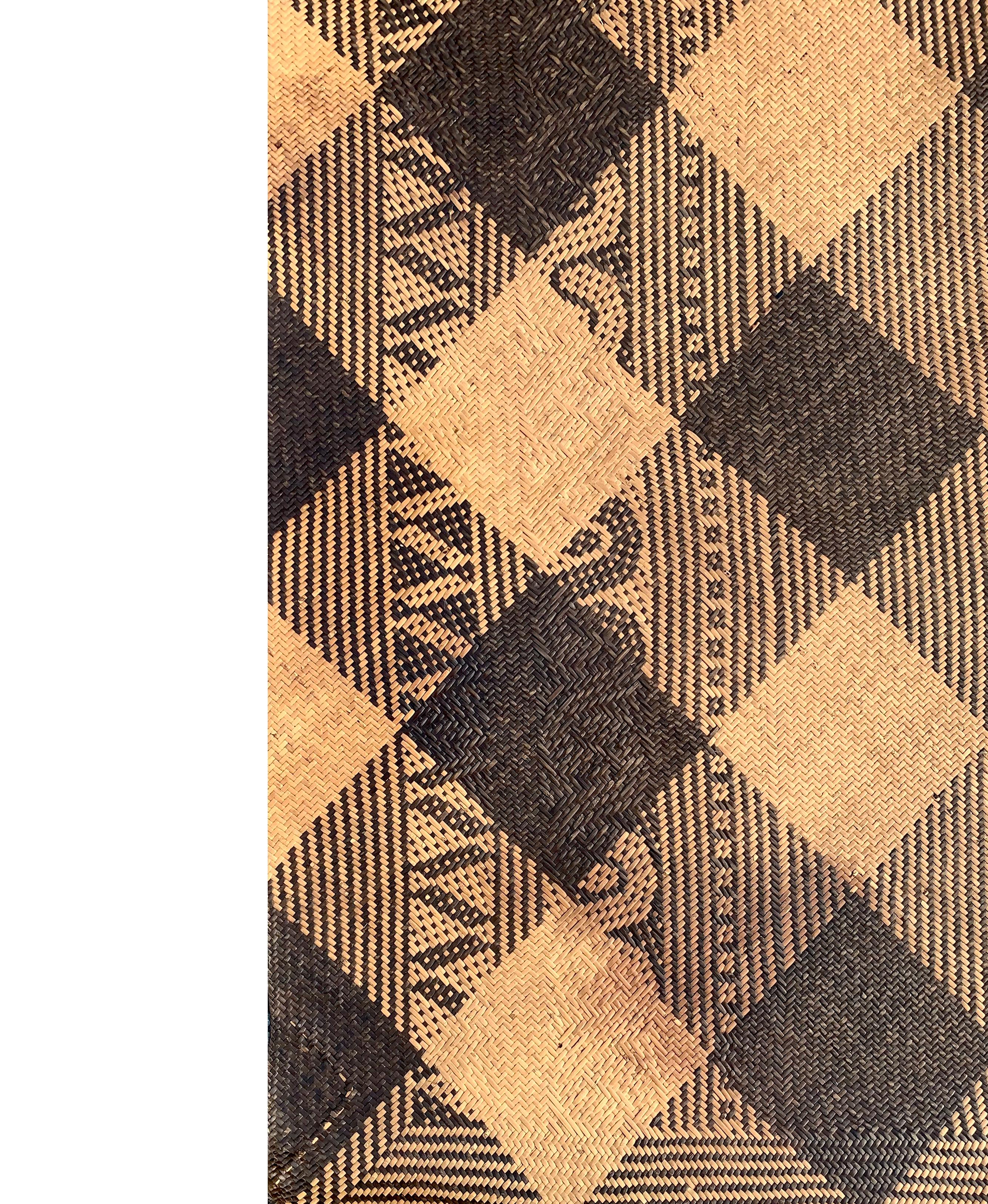 This floor mat once occupied a tribal long house of the Dayak Tribe of Borneo. It is made from woven dyed and natural coloured rattan fibres & features tribal patterns along its border. 

Dimension: Height 220cm x Width 150cm.
 