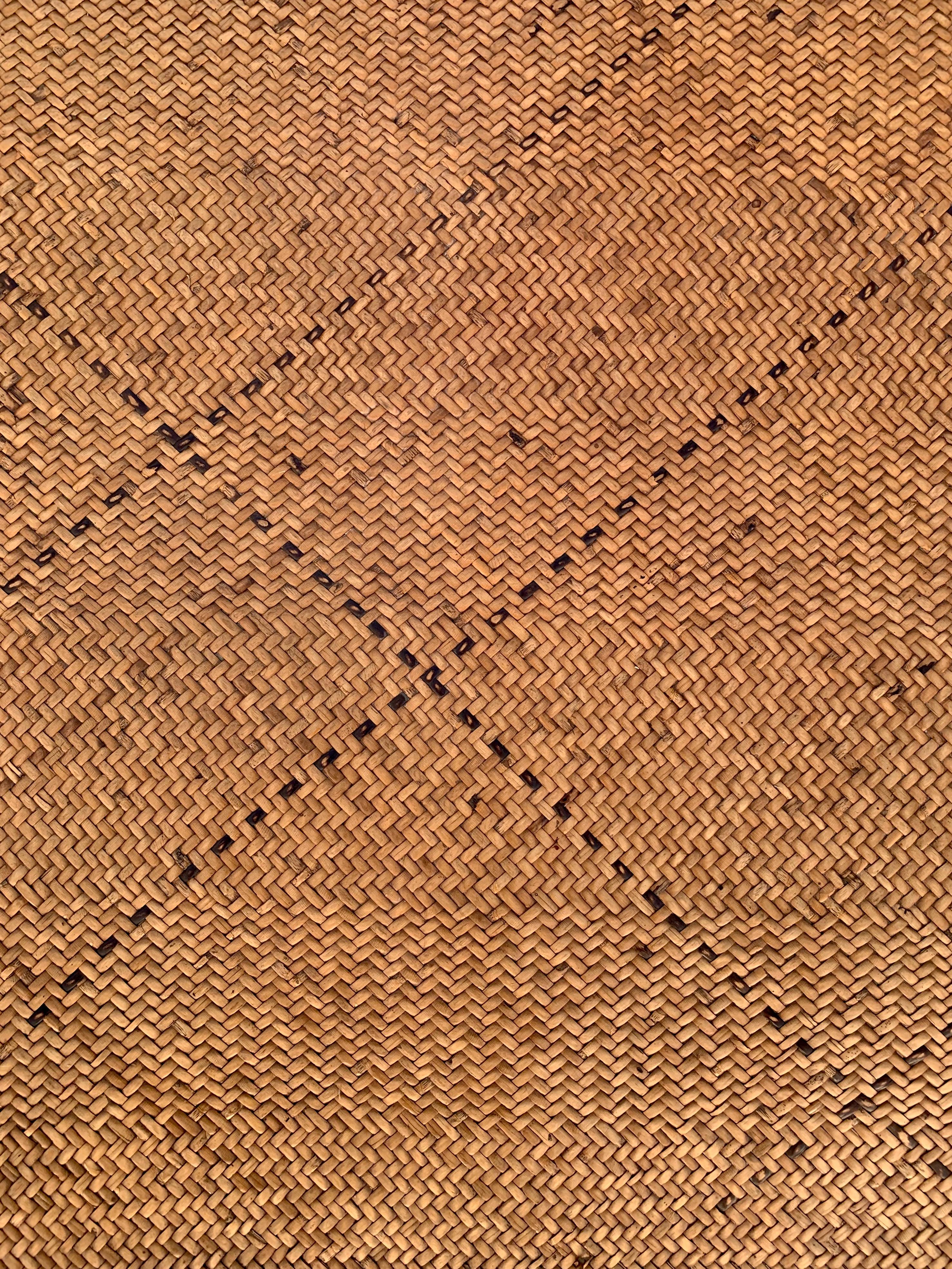 This floor mat once occupied a tribal long house of the Dayak Tribe of Borneo. It is made from woven dyed and natural coloured rattan fibres & features a subtle hint of diagonal black fibres. 

Dimension: Height 250cm x Width 160cm.
 