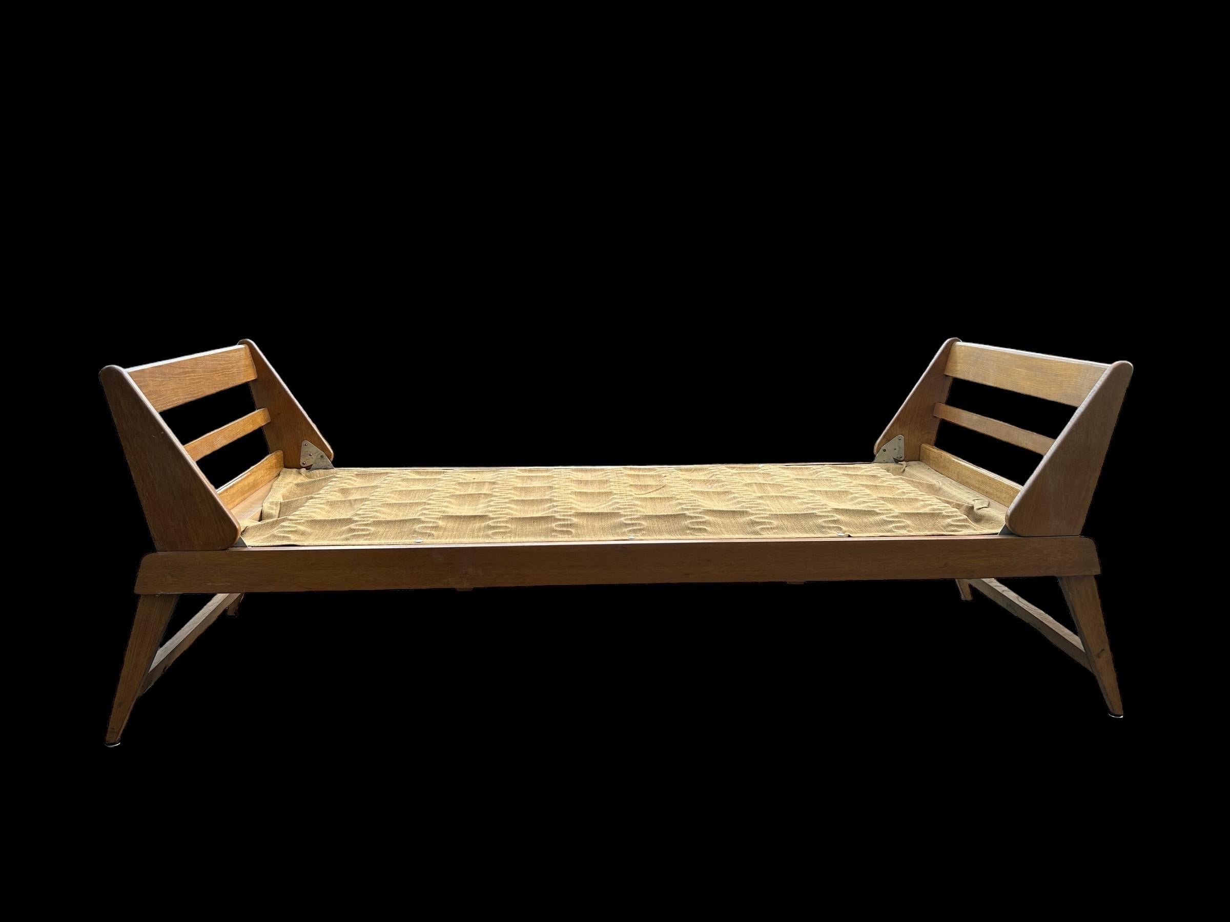 French oak daybed from the 1950's designed by René jean Caillette in original condition.
Modernist design from the master of the furniture of the post war furniture in France. 
Folding armrests and feet as pictured. 
