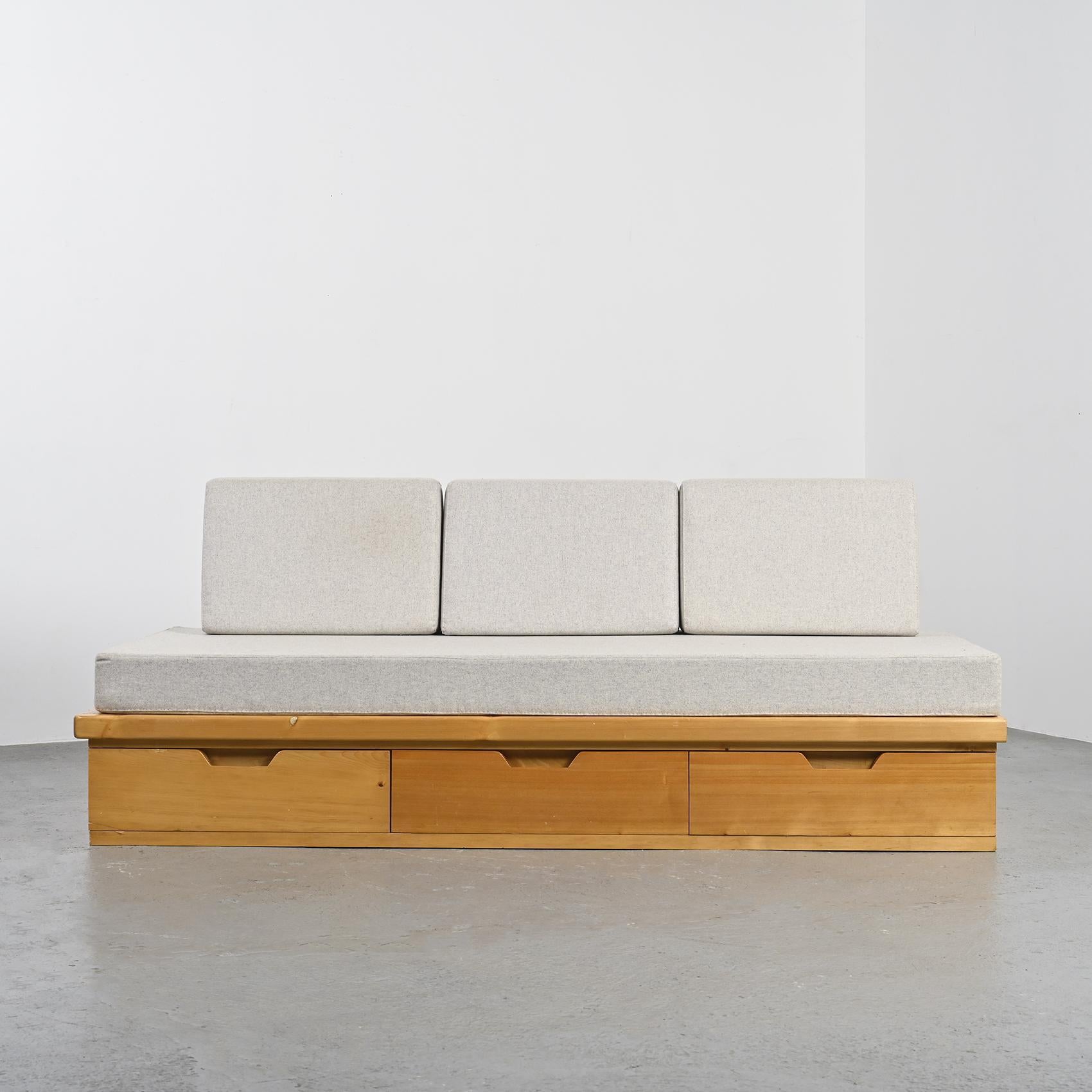 Daybed by René Martin, known as René les Ciseaux, a master cabinetmaker who collaborated with Charlotte Perriand on the design of the Les Arcs ski resort.

The structure, crafted from solid pine with a golden and dark stain, cleverly conceals three