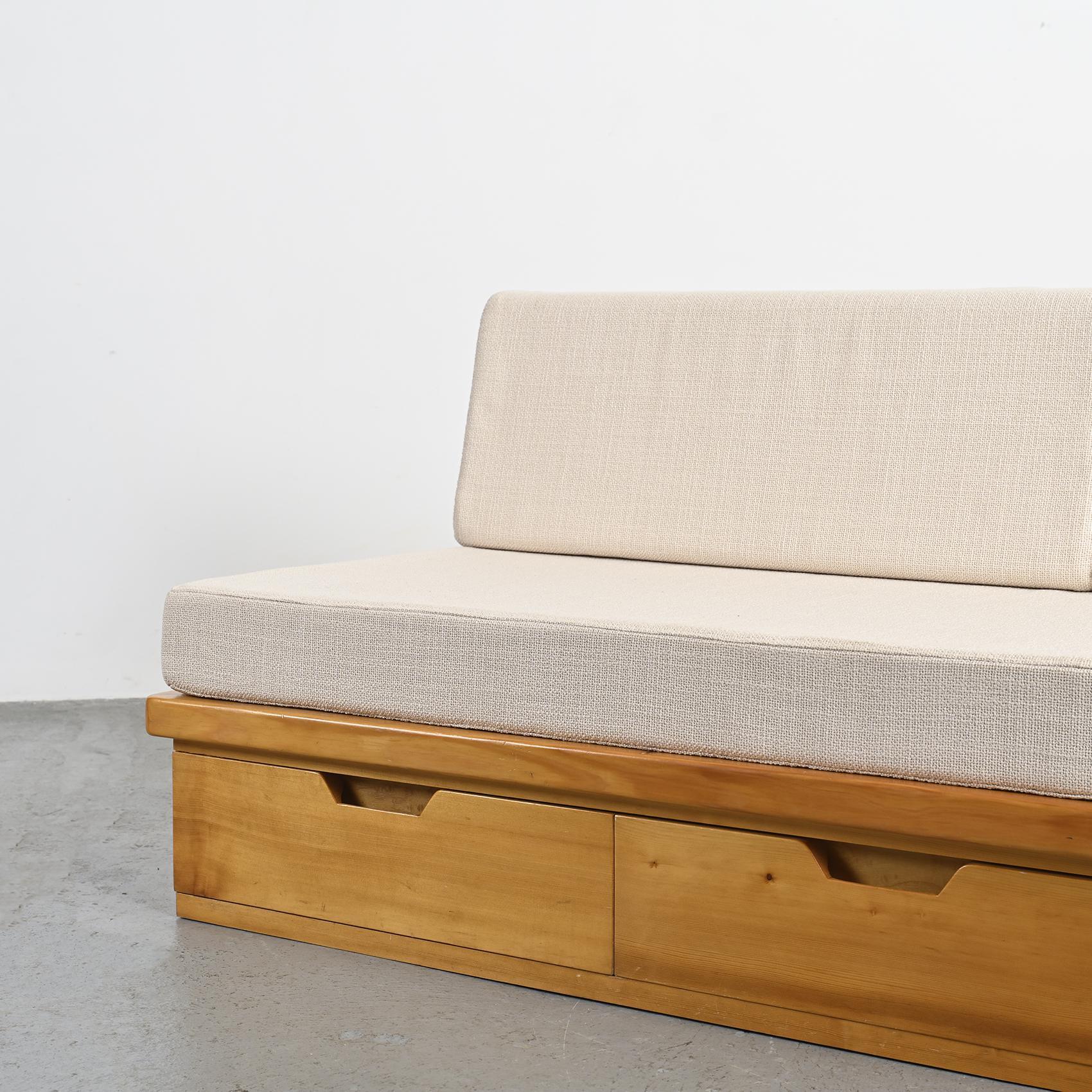 Daybed by René Martin, known as René les Ciseaux, a master cabinetmaker who collaborated with Charlotte Perriand on the design of the Les Arcs ski resort.

The structure, crafted from solid pine with a golden and dark stain, cleverly conceals three