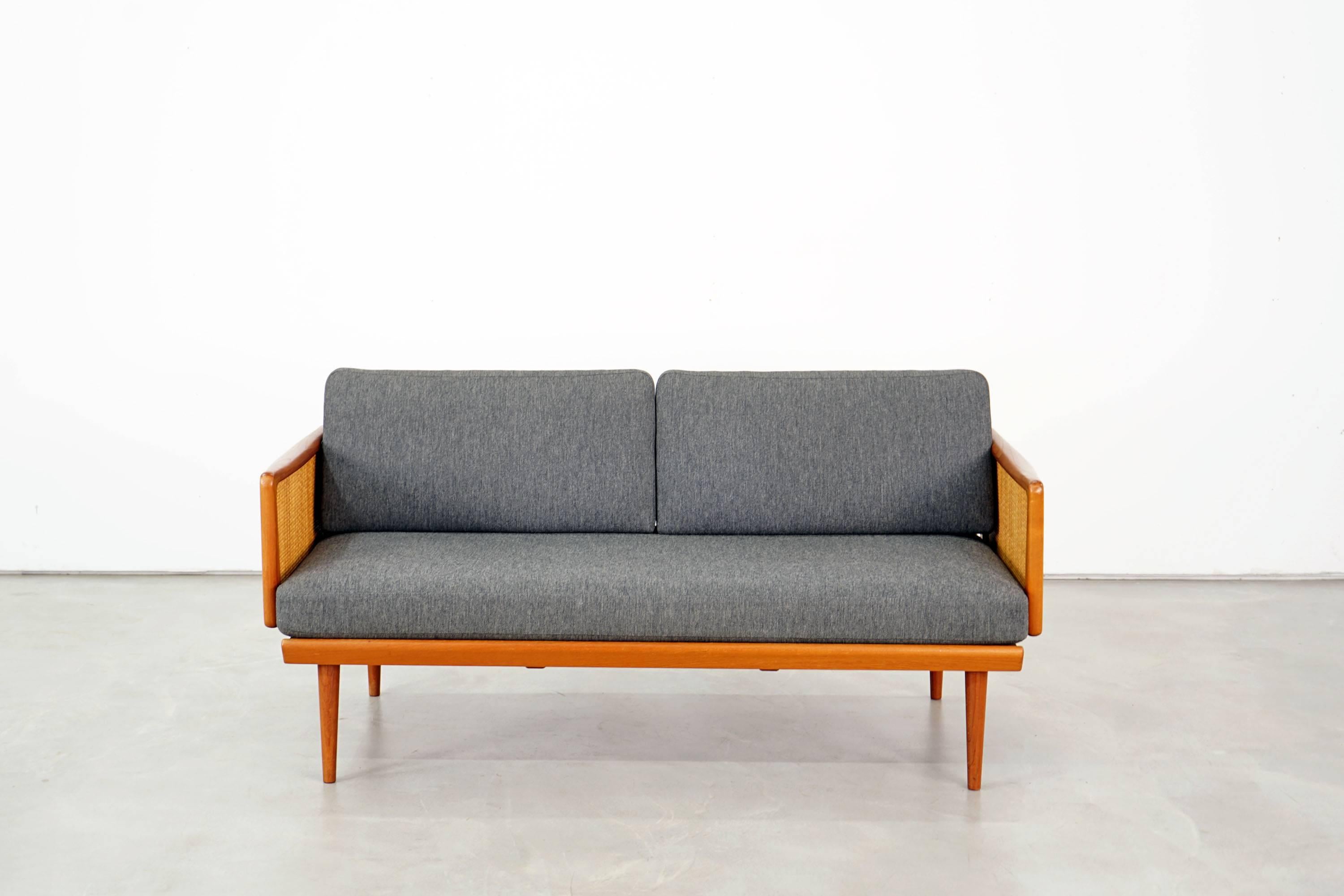 Rare classic of Scandinavian furniture by Peter Hvidt & Orla Mølgaard Nielsen. Teak and wicker frame. The loose cushions are in their original state. Both the upholstery and fabric in elegant dark grey are very well preserved. The daybed was