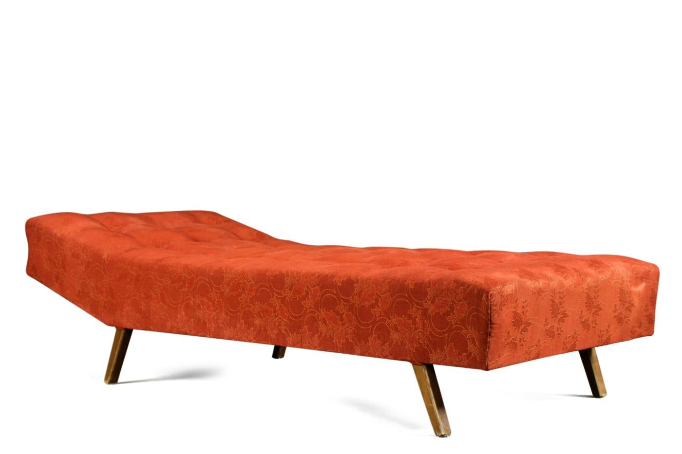 Bench, daybed design 1950s. Frame with thick padding, with feet shod with brass. Red upholstery fabrics with floral motifs. 
Dimensions ca: L. 193 cm, W 82 cm. 
With signs of age and wear.
