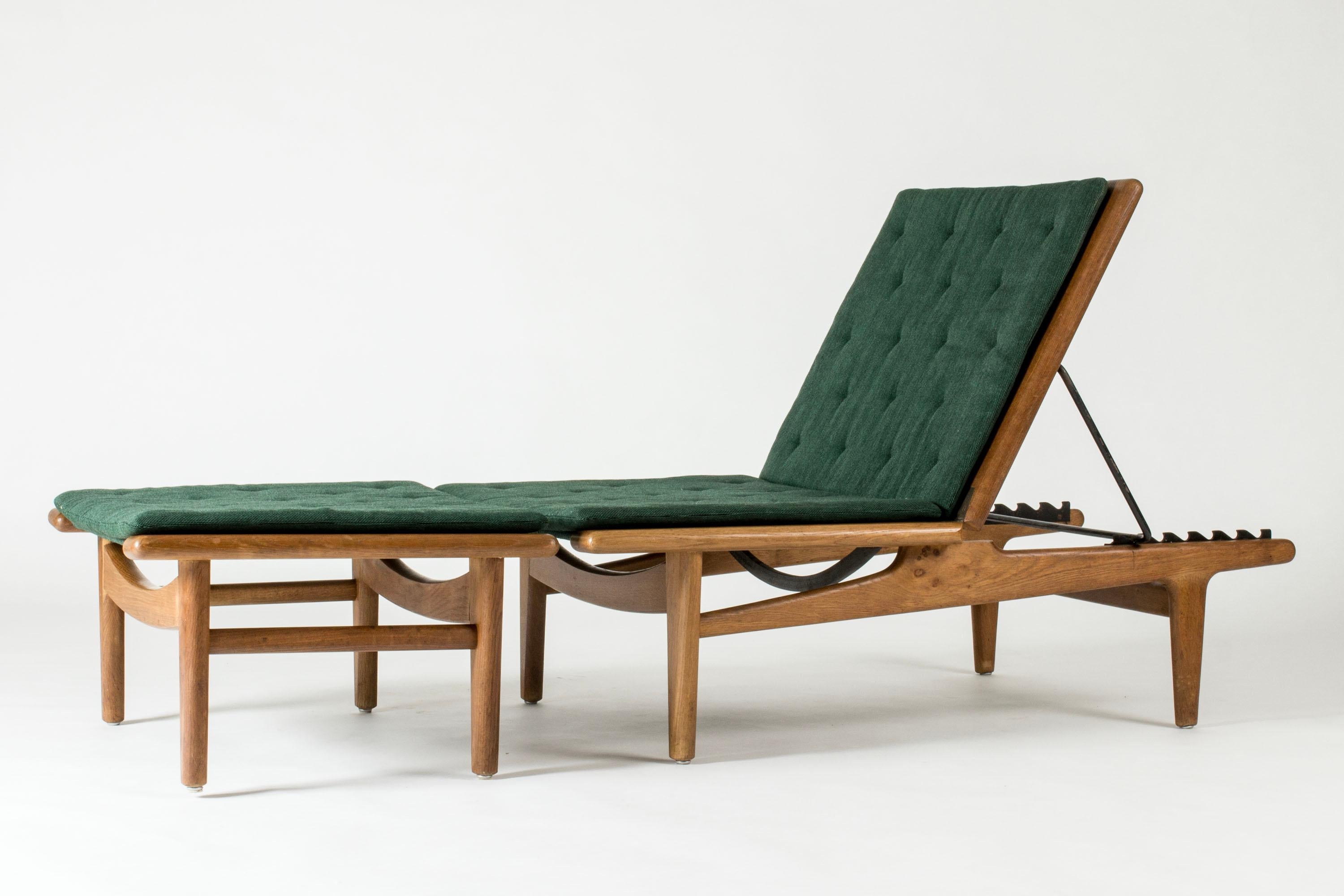 Sedia da salotto molto bella con poggiapiedi di Hans J. Wegner. Può essere posizionato in piano e trasformato in un letto da giorno. Realizzato in Oak con bellissime venature del legno, con grandi cerniere decorative in ottone. Cuscini sciolti con