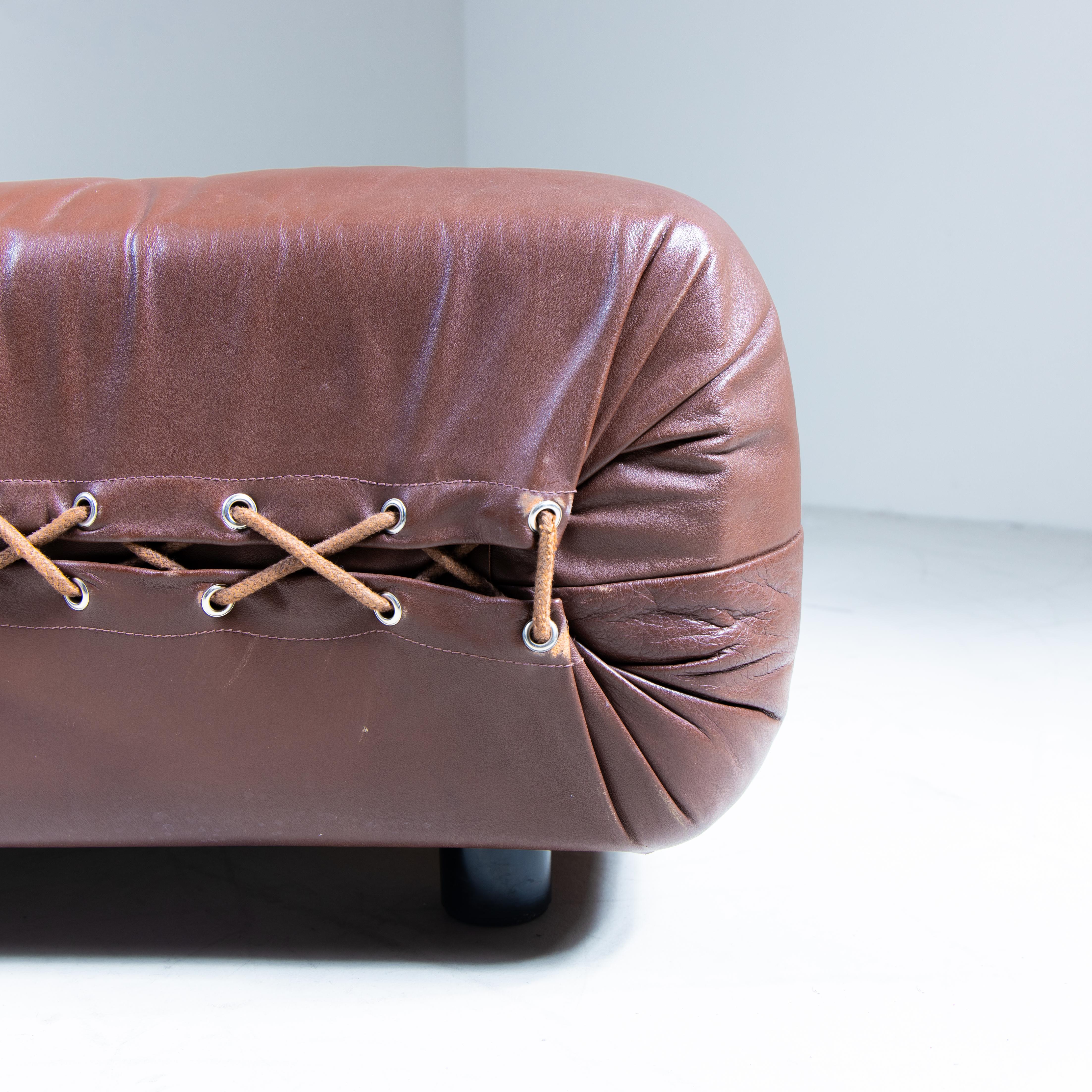 Daybed in pelle marrone, manifattura italiana, 1960. Elegante e raffinato, questo daybed è caratterizzato da un design essenziale con cuscini cilindrici e cuciture a vista, dettagli che ne enfatizzano la qualità artigianale. La struttura lineare e