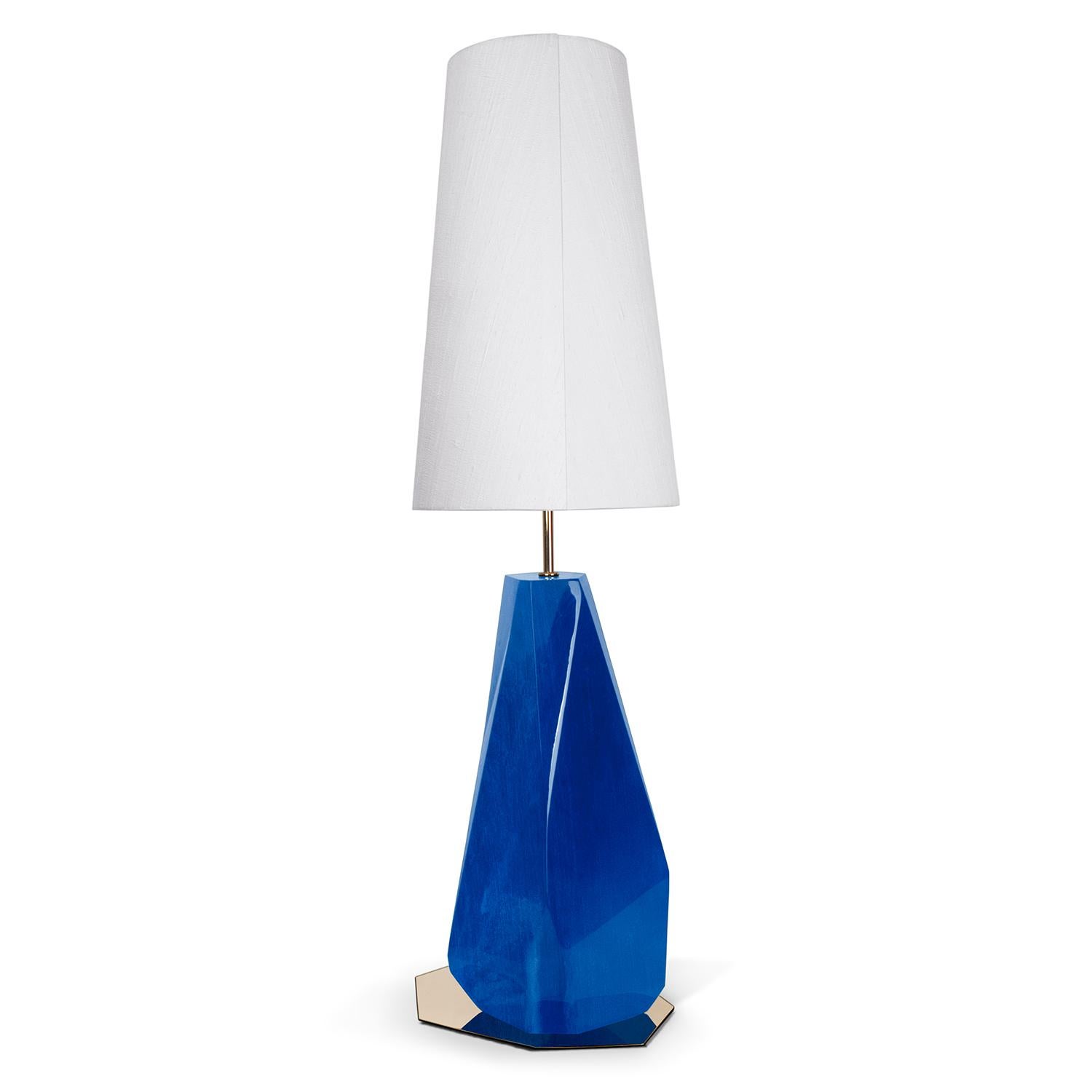 Lámpara de mesa Daytona High Azul con base de fibra de vidrio 
estructura con pan de plata recubierto de laca translúcida 
acabado. Placa base de acero inoxidable pulido en acabado dorado.
Incluye una pantalla de seda blanca. 1 bombilla, casquillo