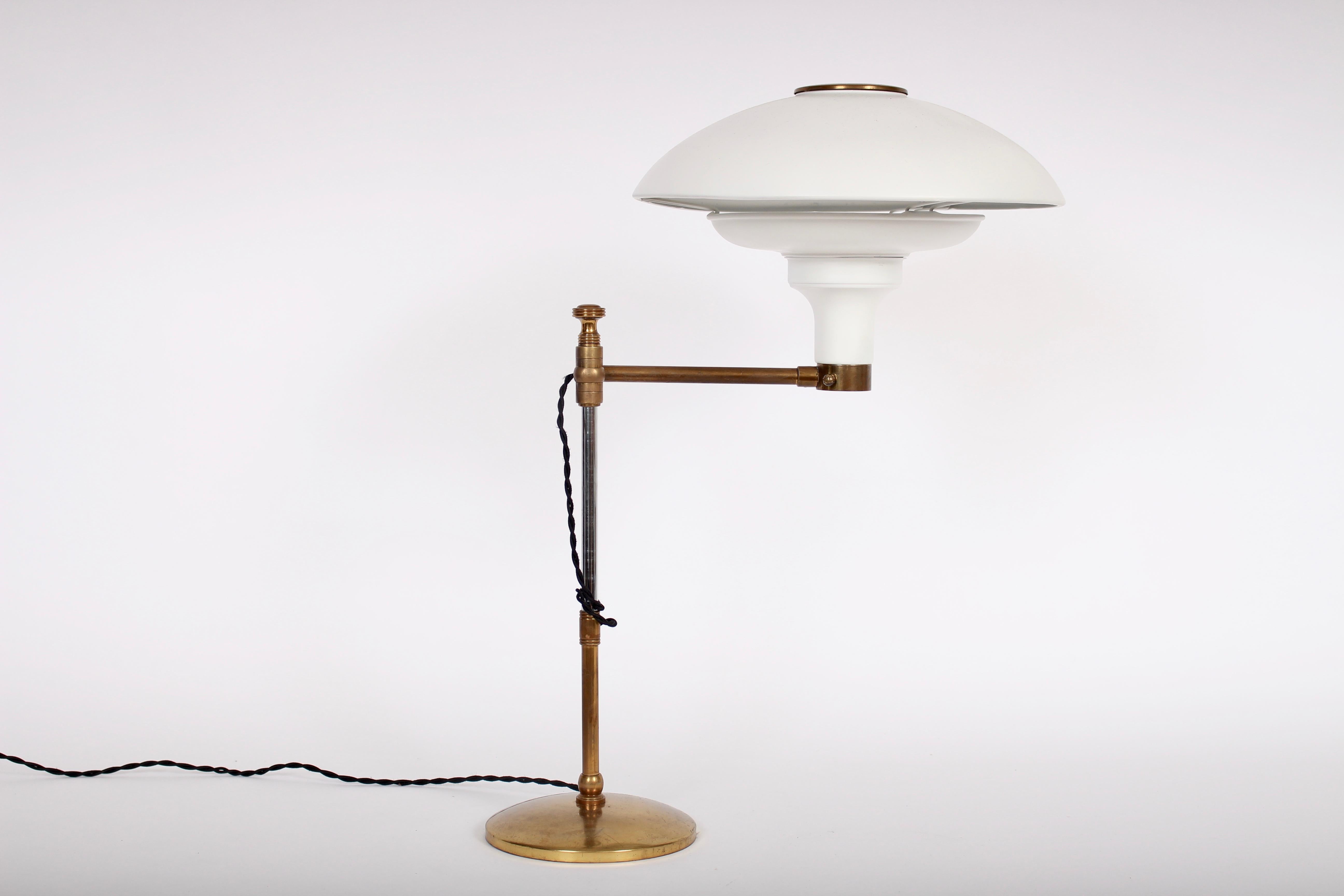 Large Art Deco Dazor attributed White Swing Arm Table Lamp with Brass details. Featuring a metal reflector perforated saucer shade, adjustable stem, swing arm, brass details and bright brass 6.5D base. Standard socket. 