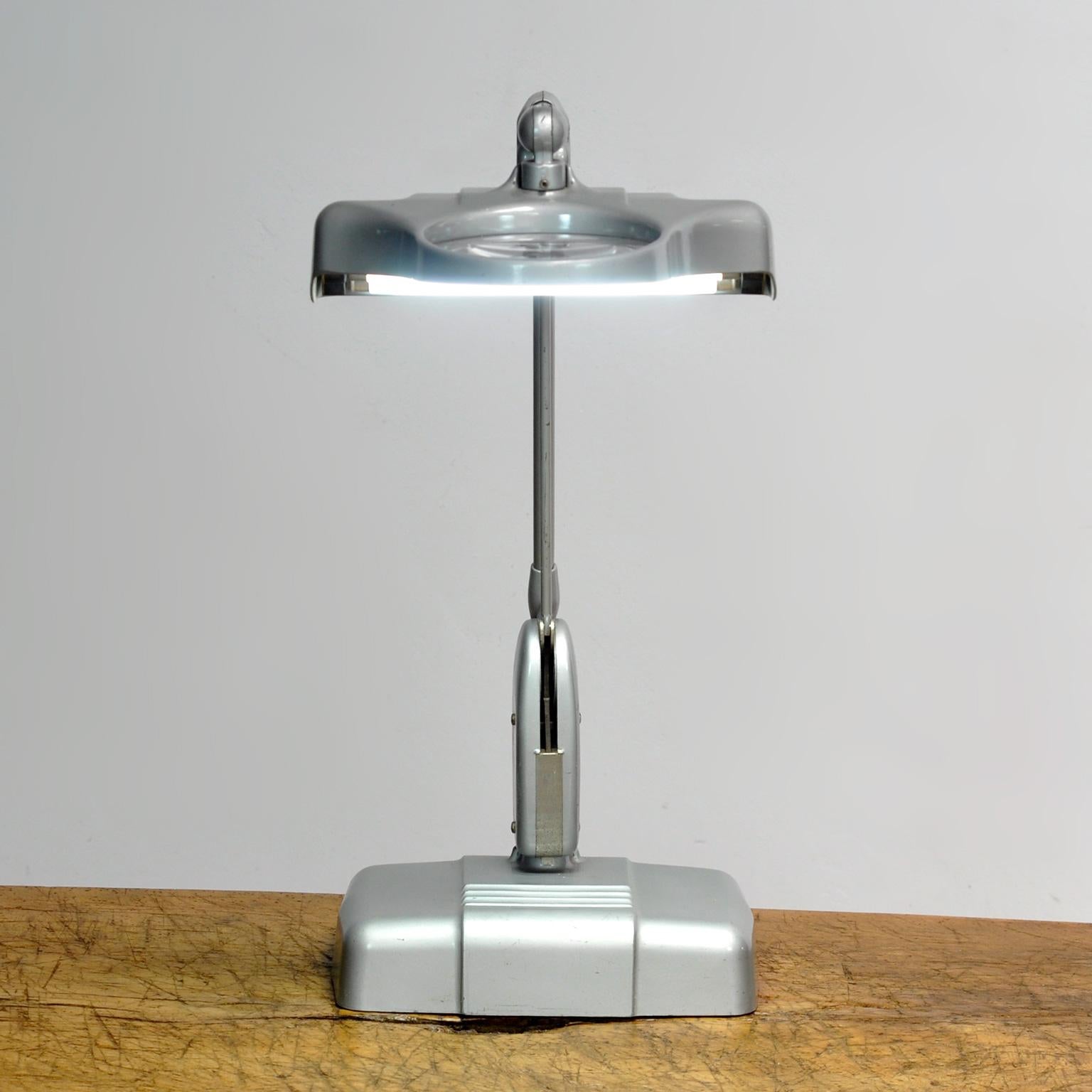 Heavy industrial Dazor work / desk lamp / goldsmith lamp with lighting and with magnifying glass, ca 1950 USA design.
Thanks to the floating fixture system and the heavy base, this lamp can be swiveled in all directions and is easy to direct as