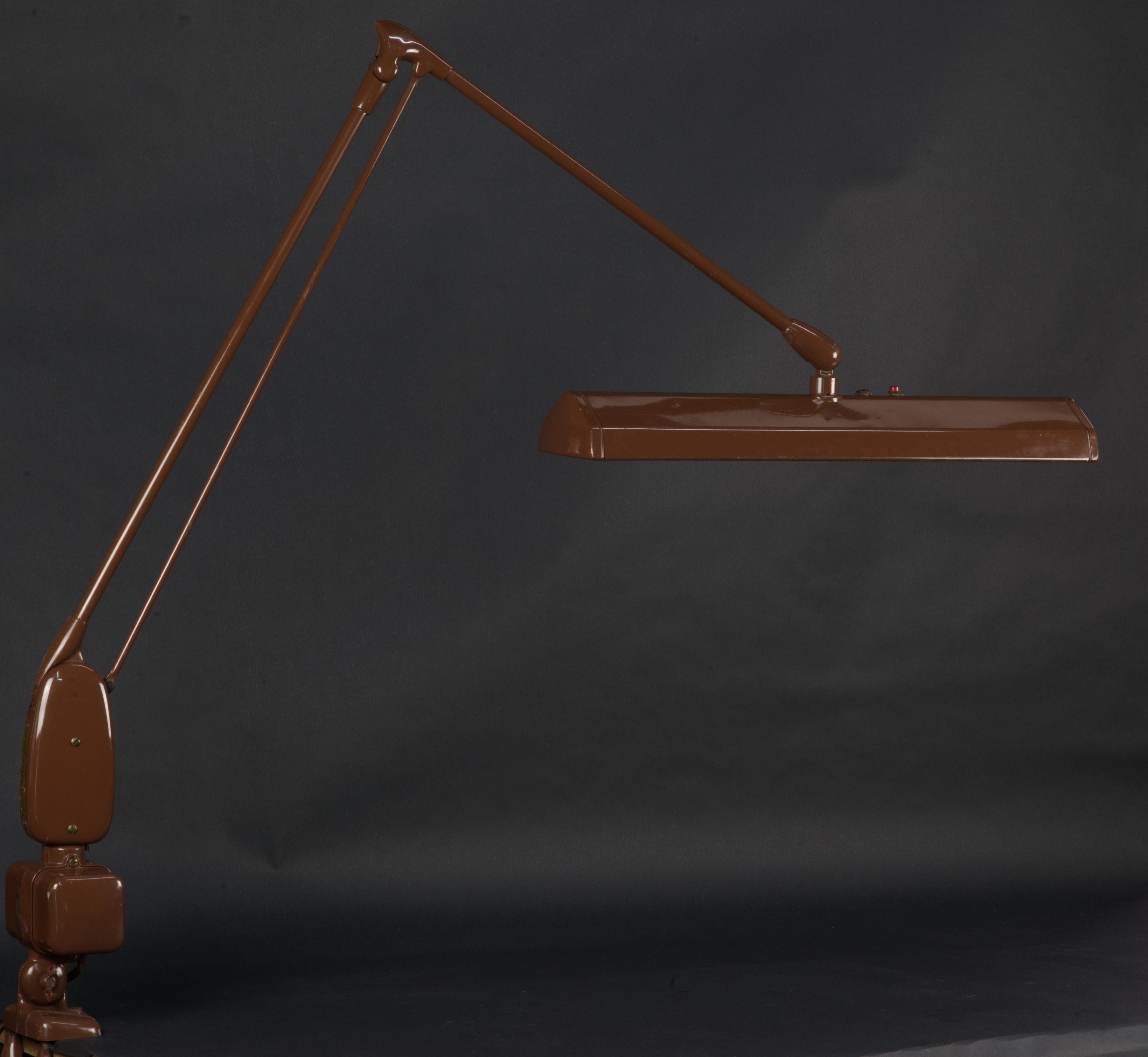 This is a famous floating arm lamp by Dazor. Company was founded in 1938 and made itself the name on this design for it's durability, ease of adjustment and most importantly, for strong an even light quality. Lamp was often used by the diamond