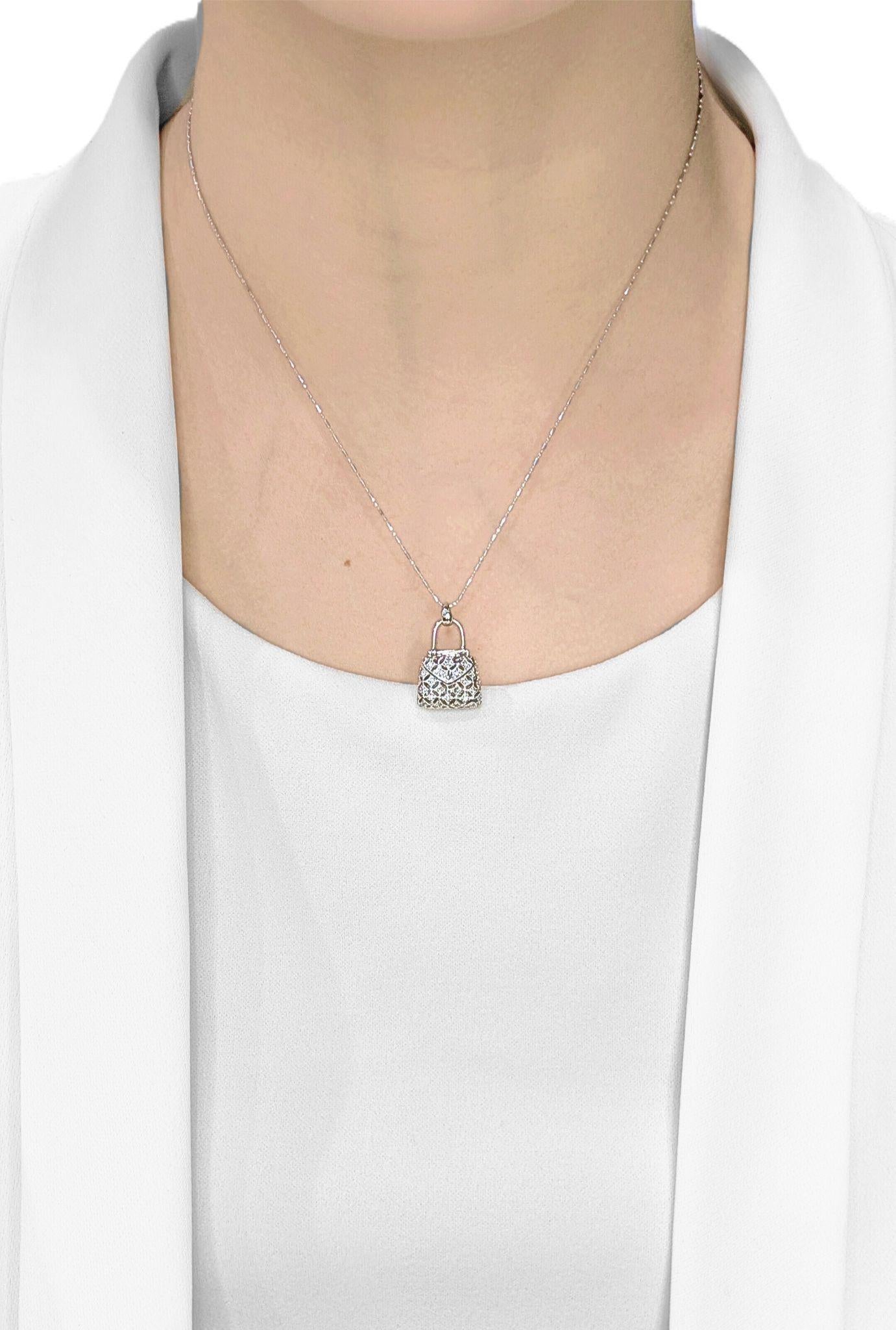 Accesoriza con caprichoso lujo con este nuevo y chic colgante, meticulosamente elaborado en radiante oro blanco de 18 quilates. Esta encantadora pieza está diseñada a semejanza de un elegante bolso de mano, exquisitamente detallado con un