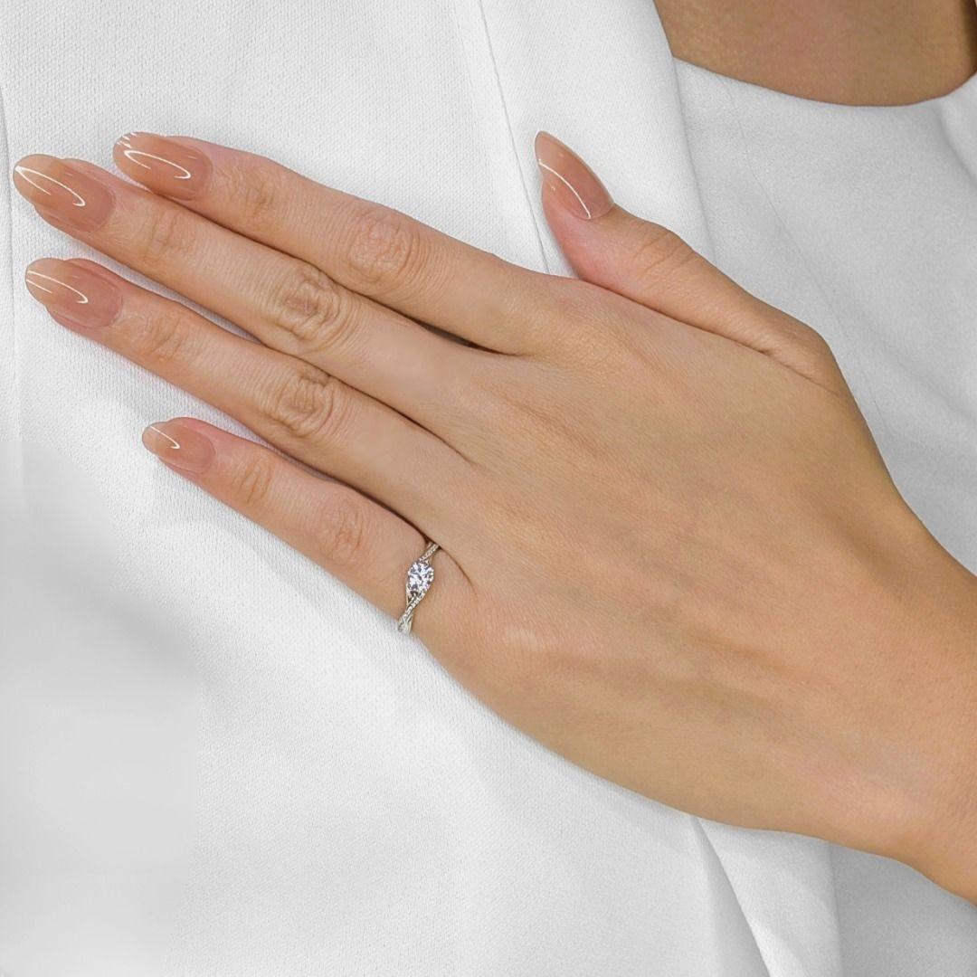 A stunning blend of elegance and artistry, this exquisite twisted band ring is crafted in 18K white gold, offering a unique yet timeless design. At its heart, a 0.3-carat round brilliant natural diamond gleams with refined G-color and VS clarity,