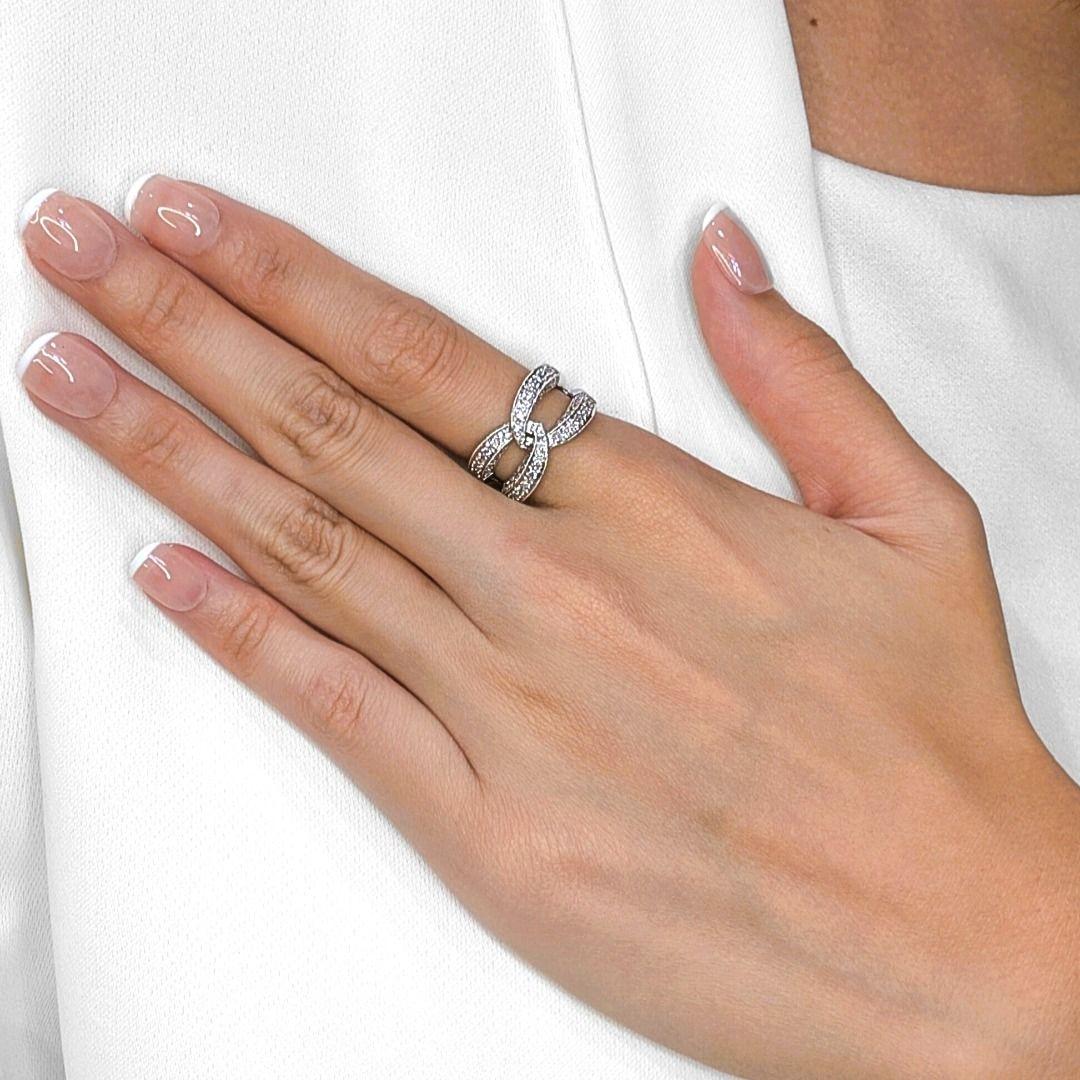 This striking pre-owned ring captures timeless sophistication with a modern twist, beautifully crafted in lustrous 18K white gold. Designed in an infinity-inspired motif, it is set with 74 round brilliant natural diamonds, totaling 0.74 carats. Each