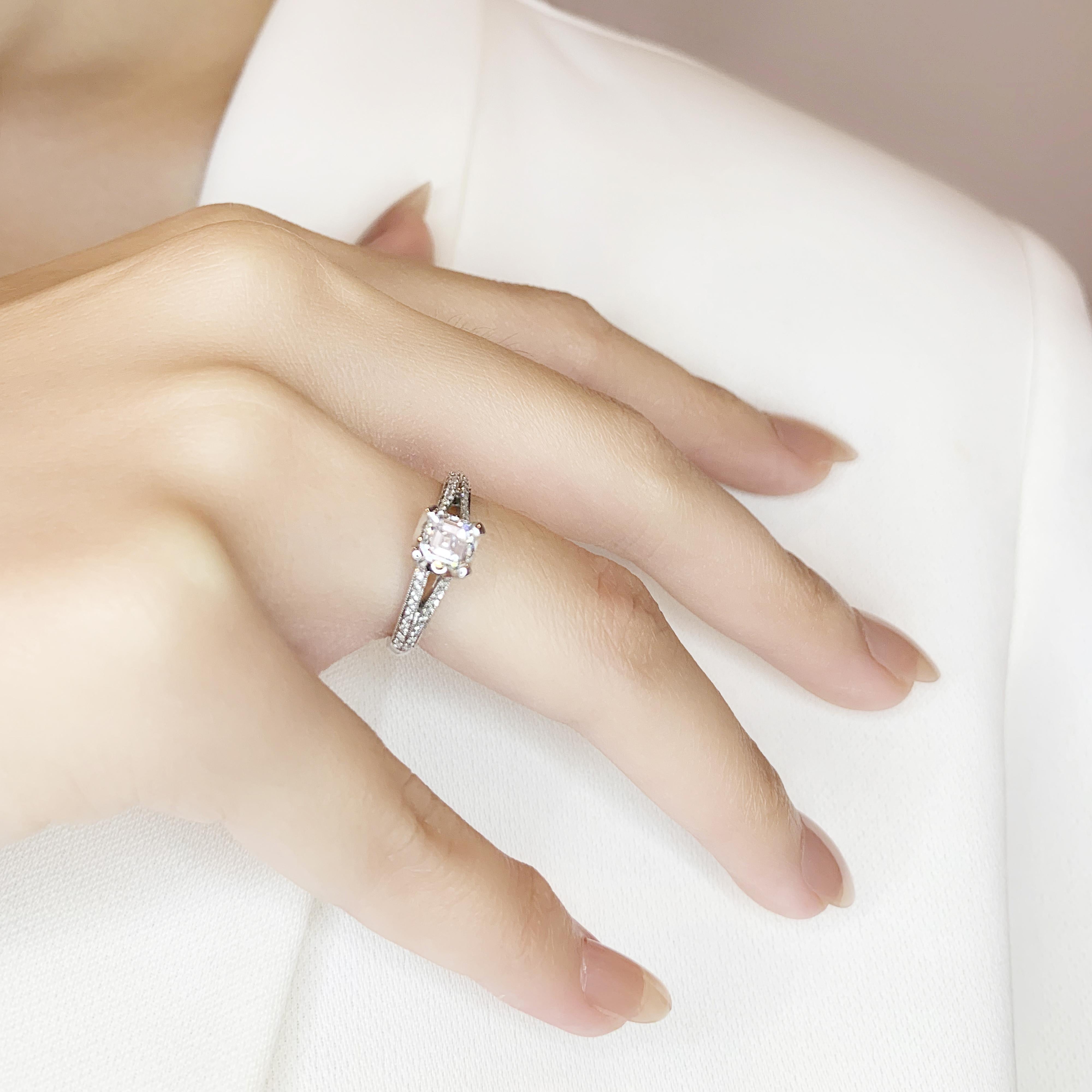 This glorious pave ring features a stunning emerald cut diamond as its centerpiece, weighing 0.71ct, and is set in 18K white gold. The main stone boasts an impressive F color grade and VS clarity grade, providing exceptional brilliance and clarity.