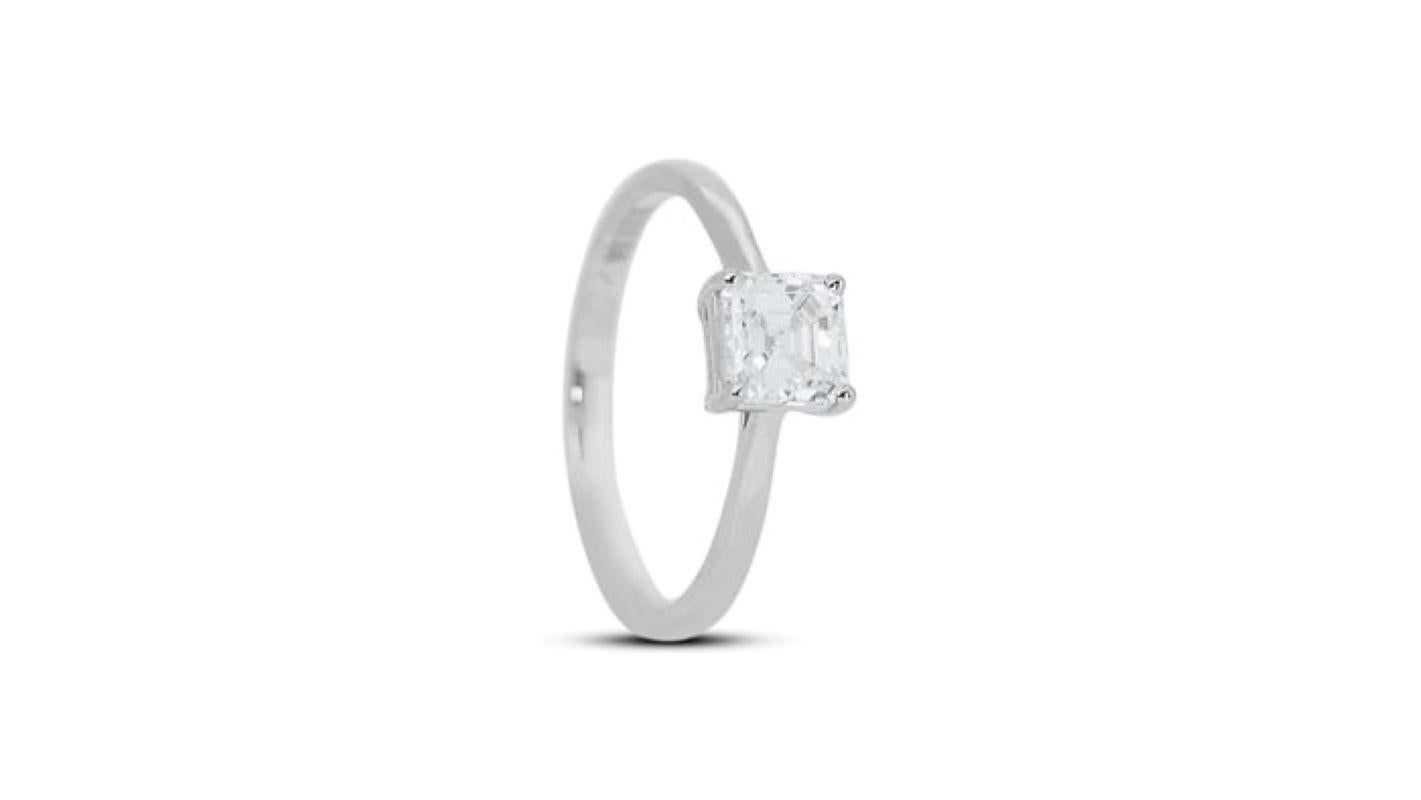 Embrace timeless elegance with this captivating ring, showcasing a mesmerizing 1.25 carat asscher diamond, boasting exceptional brilliance and geometric charm. The meticulously cut center stone, renowned for its captivating square step cuts and