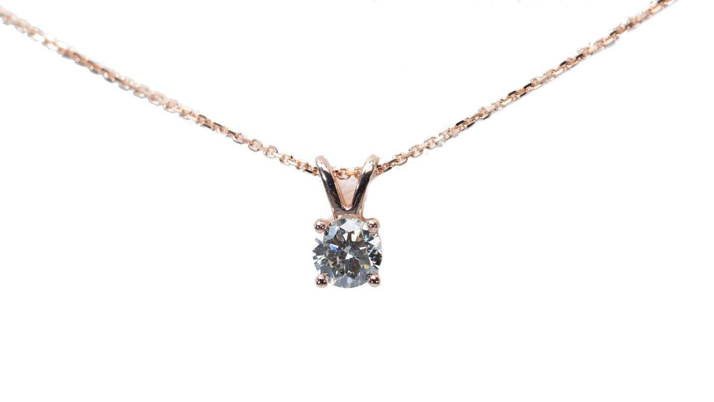 A stunning solitaire necklace with a dazzling 1-carat round brilliant natural diamond in J IF. The jewelry is made of 18K Pink Gold with a high-quality polish. The main stone is engraved with a laser inscription and has a GIA certificate and a fancy
