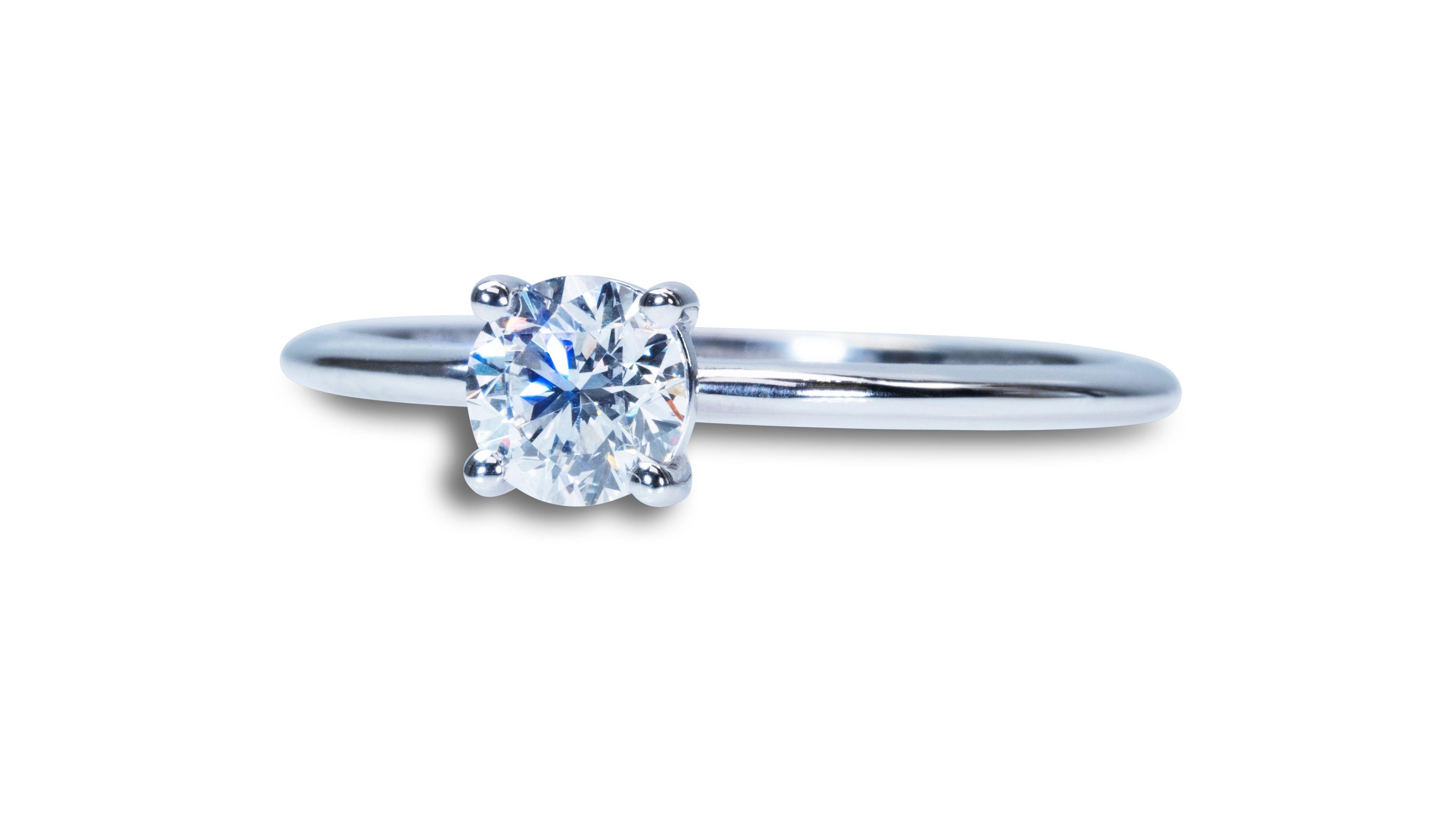 A beautiful classic solitaire ring with a dazzling 1 carat Round Brilliant natural diamond in EVVS2 quality and ideal cut what's means extremely bright and sparkles Natural Diamond. The jewelry is made of 18k white gold with a high quality polish.