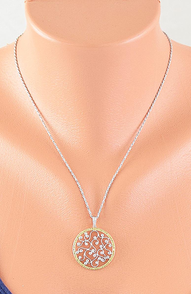Presented is a stunning 18 karat white and yellow gold and diamond pendant on a 14 karat white gold chain. The pendant is round with vine-like milgrain finish filigree, set with diamonds. 

 The 'vines' are bezel set with 25 total modern brilliant