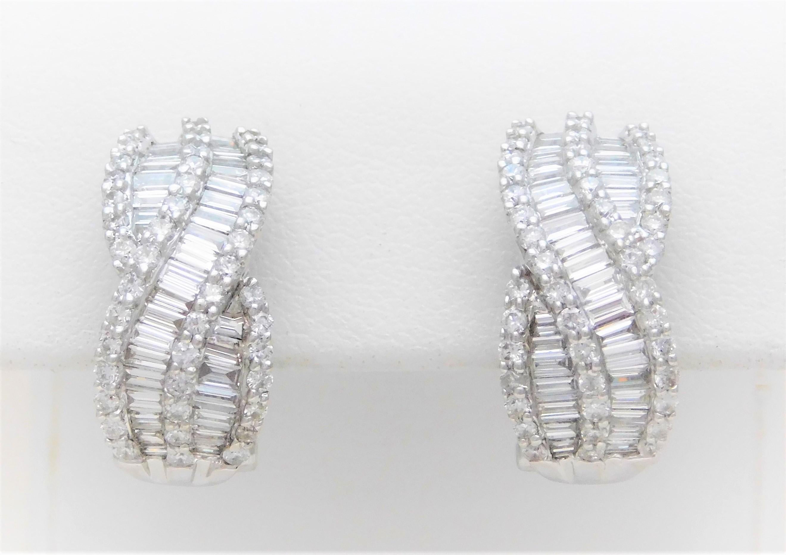 These modern drop-style earrings have been crafted in solid 18k white gold.  They have each been adorned with a total of 33 baguette-cut and 44 round full-cut natural high-quality diamonds approximating 2.60 carats in total diamond weight.  The