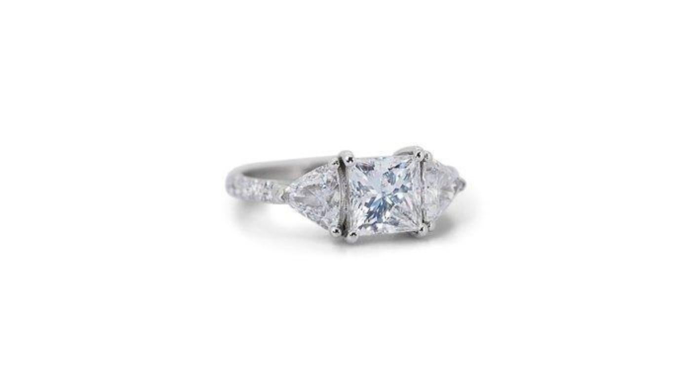 This exquisite ring is a sparkling testament to timeless elegance and captivating brilliance. The centerpiece is a breathtaking 1.7 carat princess cut diamond, boasting the coveted D color (colorless) and VS1 clarity (minute inclusions barely
