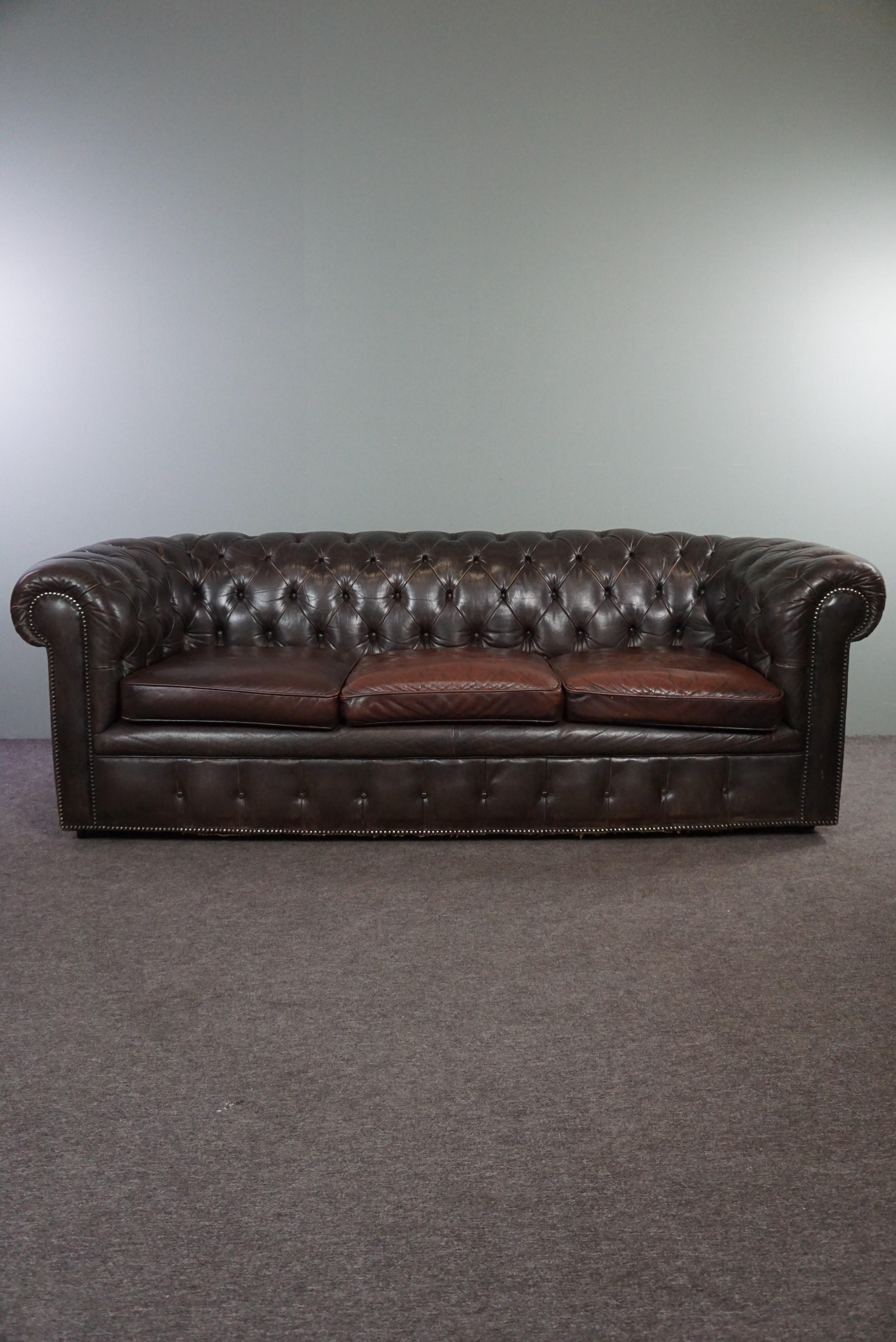Offered is this wonderfully comfortable cowhide 3-seater Chesterfield sofa with an amazing appearance due to its patina and design.

This beautiful Chesterfield filled with horsehair has aged in a very beautiful way.
Anyone who takes this unique