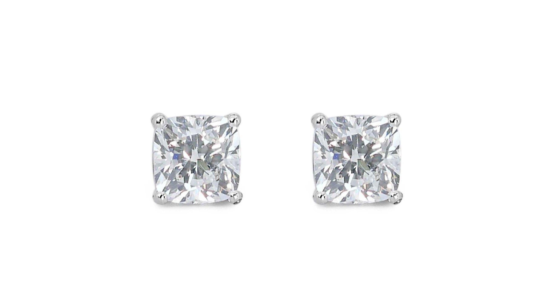 This stunning pair of 18K white gold earrings features a dazzling 2.06 carat square modified diamond in each ear. The diamonds are certified by IGI as G-H color, VS2 clarity, and VG cut grade. This means that the diamonds are nearly colorless and