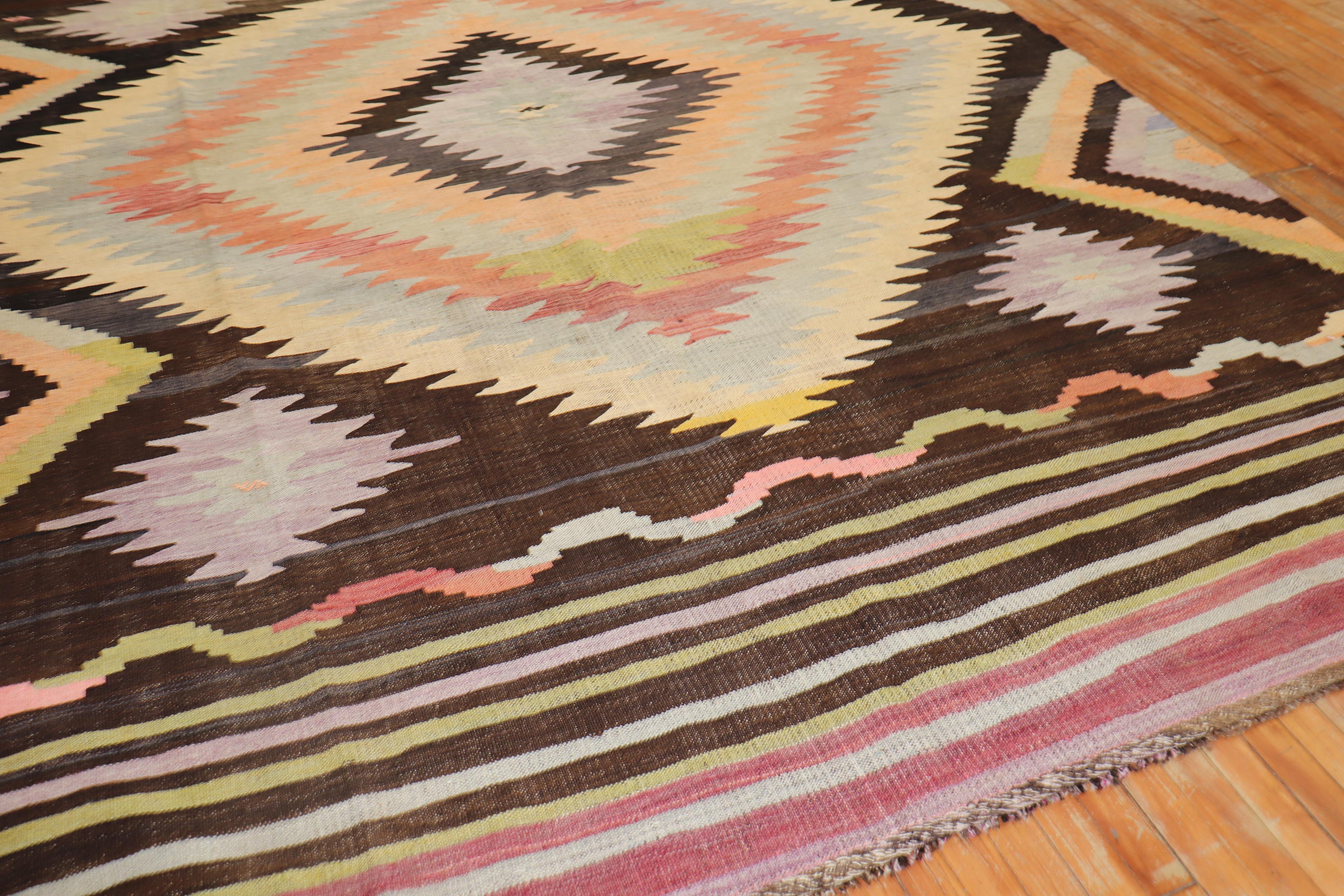 Room size Turkish Kilim from the mid-20th century. The field is brown, accents in canteloupe, peach, light green and lavender.

Measures: 8'4
