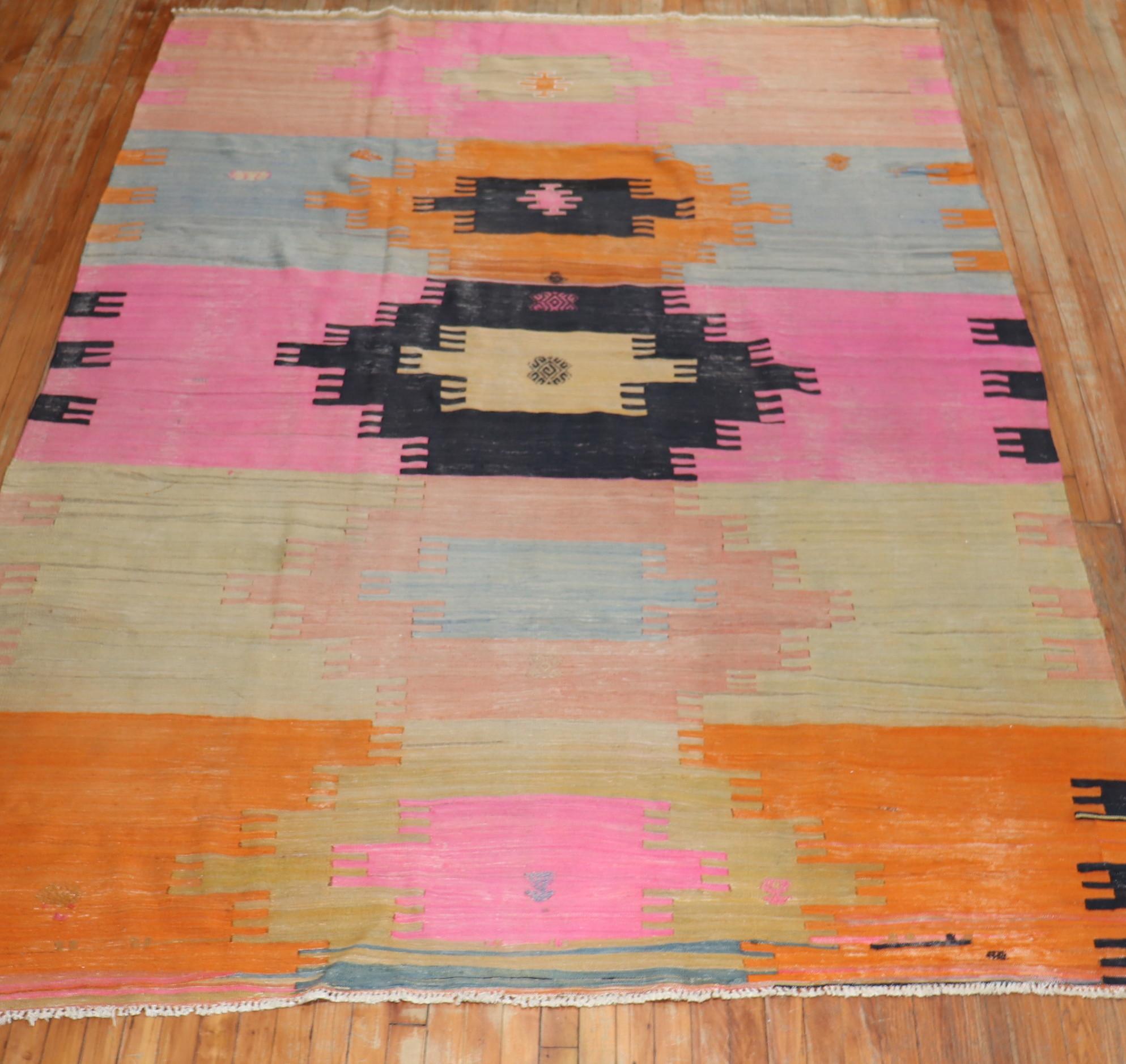 A room size Turkish Kilim from the mid-20th century highlighted in bright pink & orange shades

Measures: 7' x 10'2