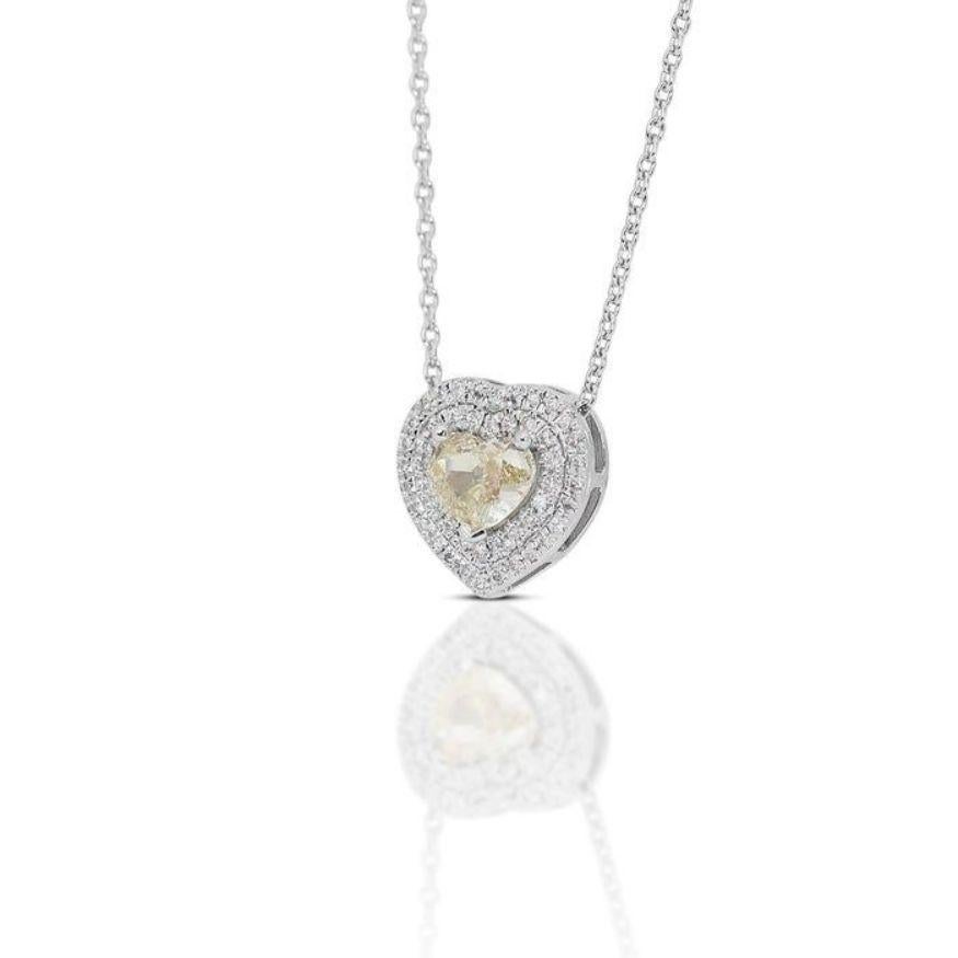 This exquisite necklace isn't just an accessory; it's a captivating story told in diamonds. At its heart, nestled in 18K white gold polished to a high shine, lies a magnificent 0.88-carat heart-shaped diamond. Its fancy yellow color evokes the