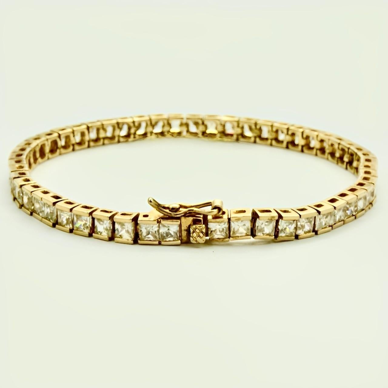 Beautiful gold vermeil on sterling silver tennis bracelet with a safety catch, set with clear faceted rhinestones in open back settings. Measuring length 18.8 cm / 7.4 inches by width 4 mm / .15 inch, and depth 3 mm / .11 inch.

This is a classic