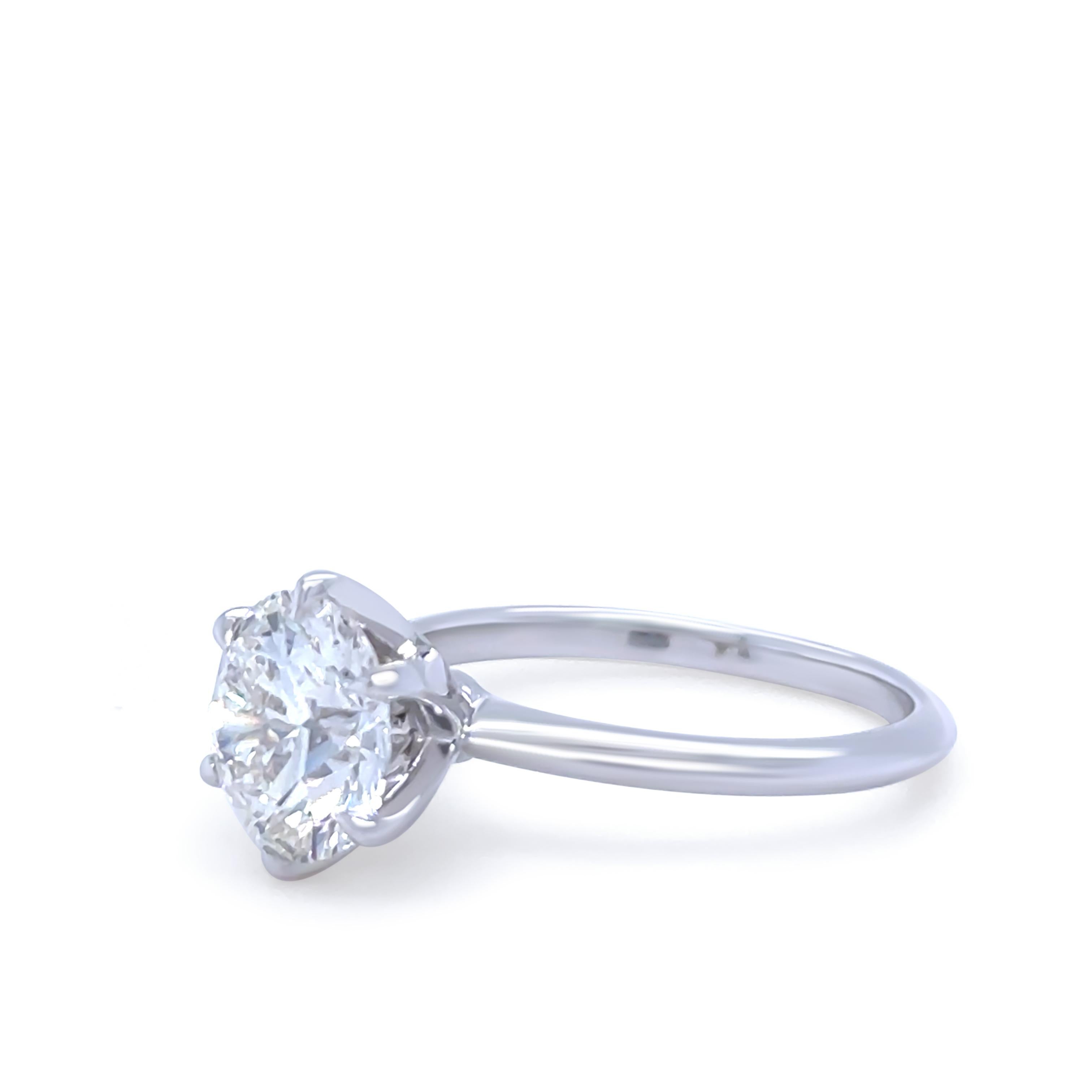 Este excepcional anillo de compromiso de diamantes está elaborado en oro blanco de 18 quilates y tiene como pieza central un asombroso diamante redondo de talla brillante de 2,11 quilates. El diamante está certificado por la DCLA y tiene una