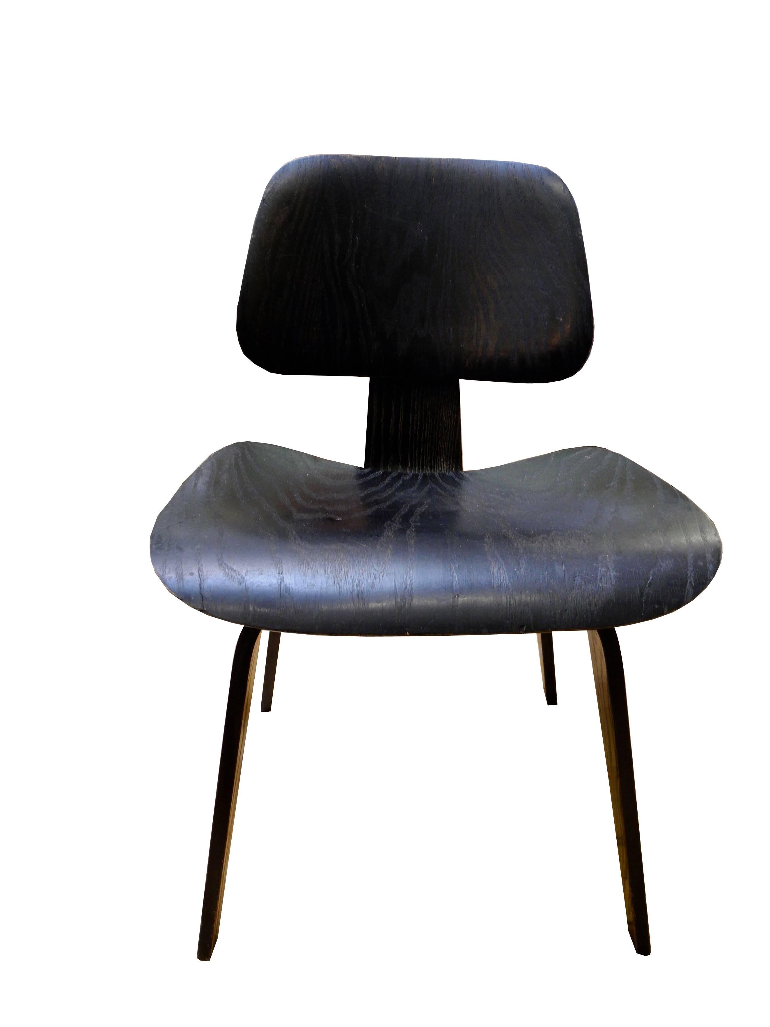 This original molded plywood dining height chair in black was designed by Charles Eames, manufactured by Evans Company and distributed by Herman Miller.
