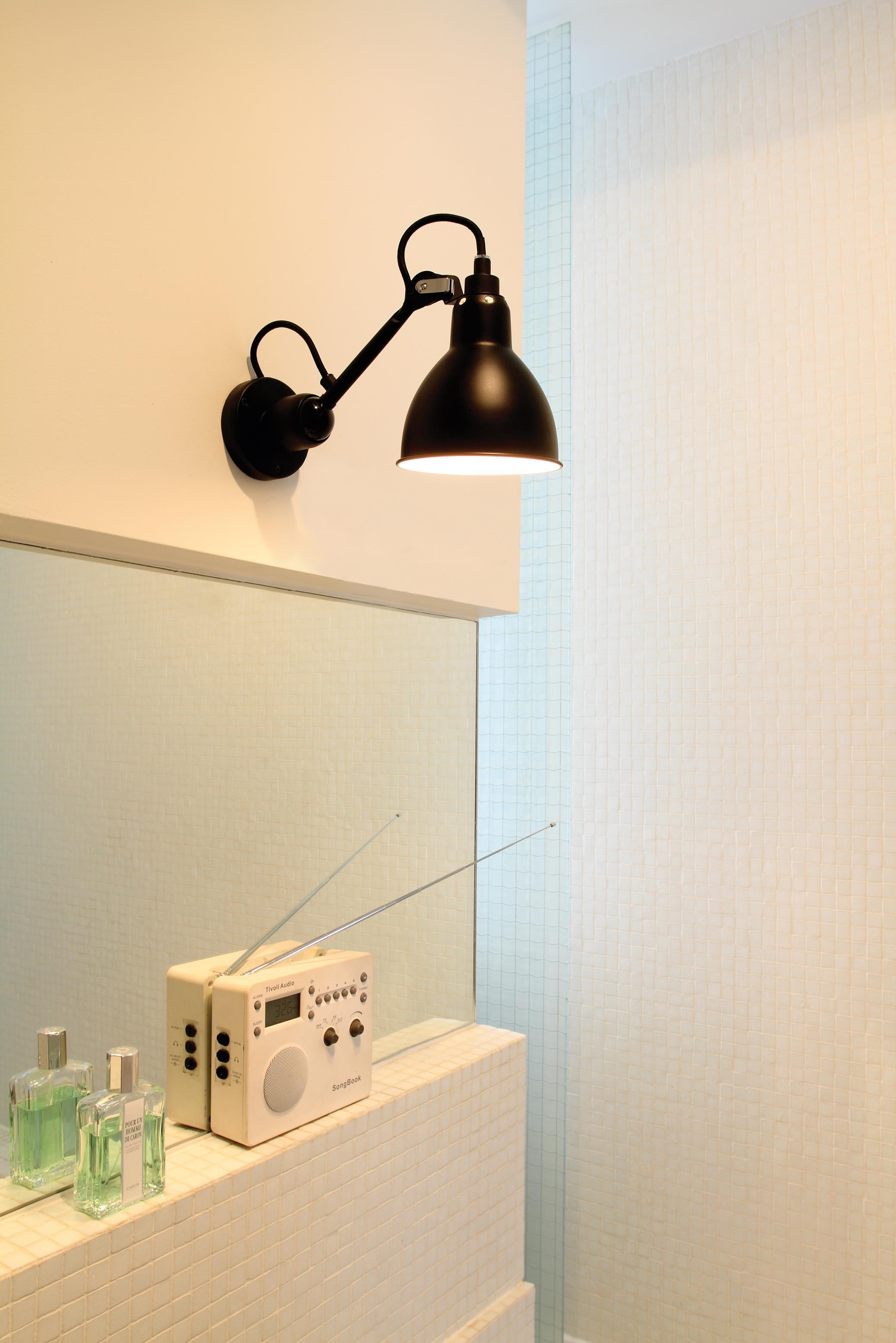 Lámpara de pared DCW Editions La Lampe Gras N°304 con brazo de acero blanco y pantalla cromada de Bernard-Albin Gras
 
 En 1921, Bernard-Albin GRAS diseñó una serie de lámparas para su uso en oficinas y en entornos industriales. La lámpara GRAS,