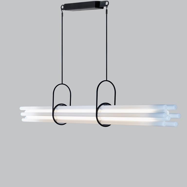 DCW Editions NL12 Pendant Lamp in Black Glass and Aluminum by Sebastian Summa
 
Designed to illuminate a large dining room table, this light cleverly fitted with an eye-deceiving device, is composed of twelve borosilicate glass tubes. Only one of